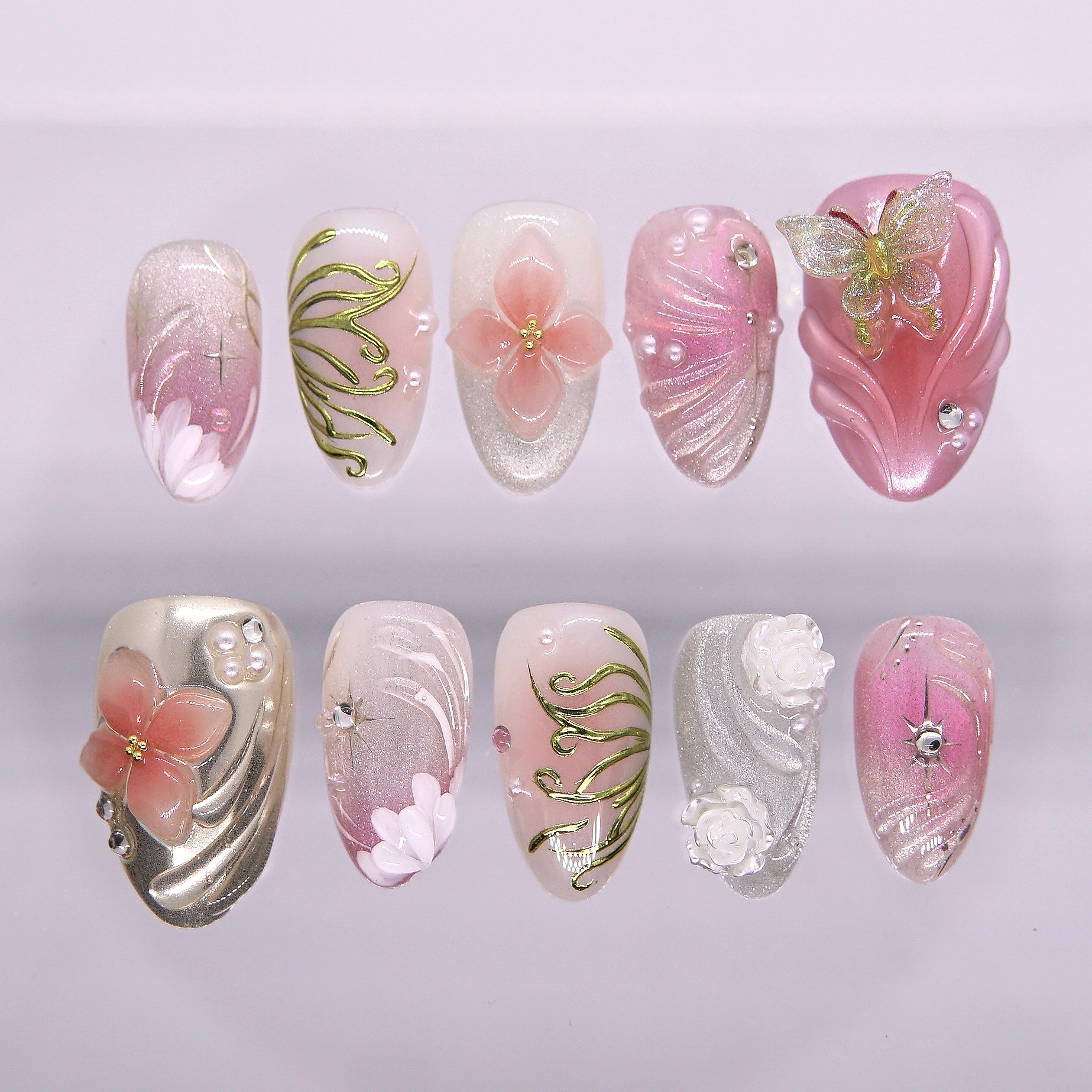 Pink fantasy press-on nails with sculpted 3D florals, butterflies, and golden vines from the Water · Flow collection by Nailsium.