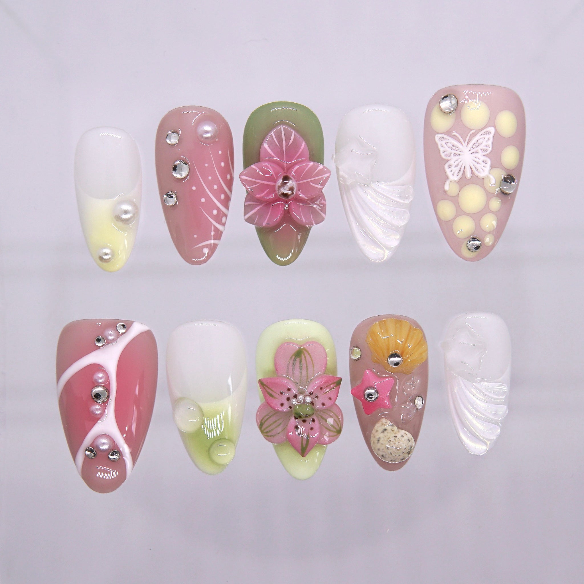 Tropical Whispers press-on nails with pink blossoms, green leaves, shells, and starfish accents – fresh Wood · Bloom design by Nailsium.
