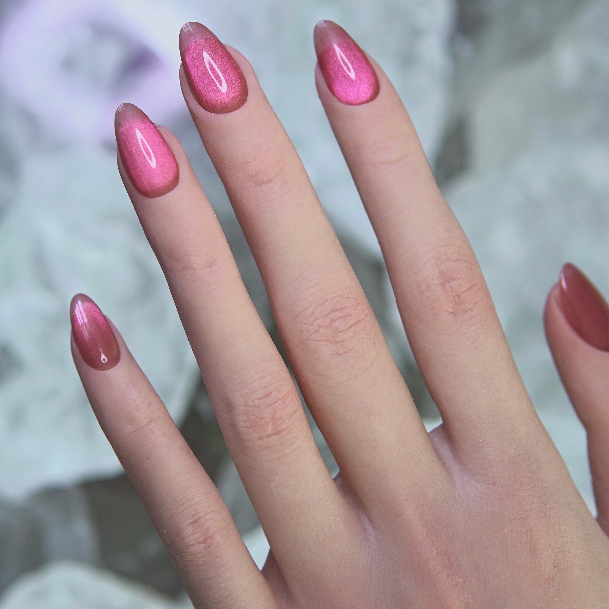 Hand wearing Blush Rush nails, styled with gold rings and warm lighting.
