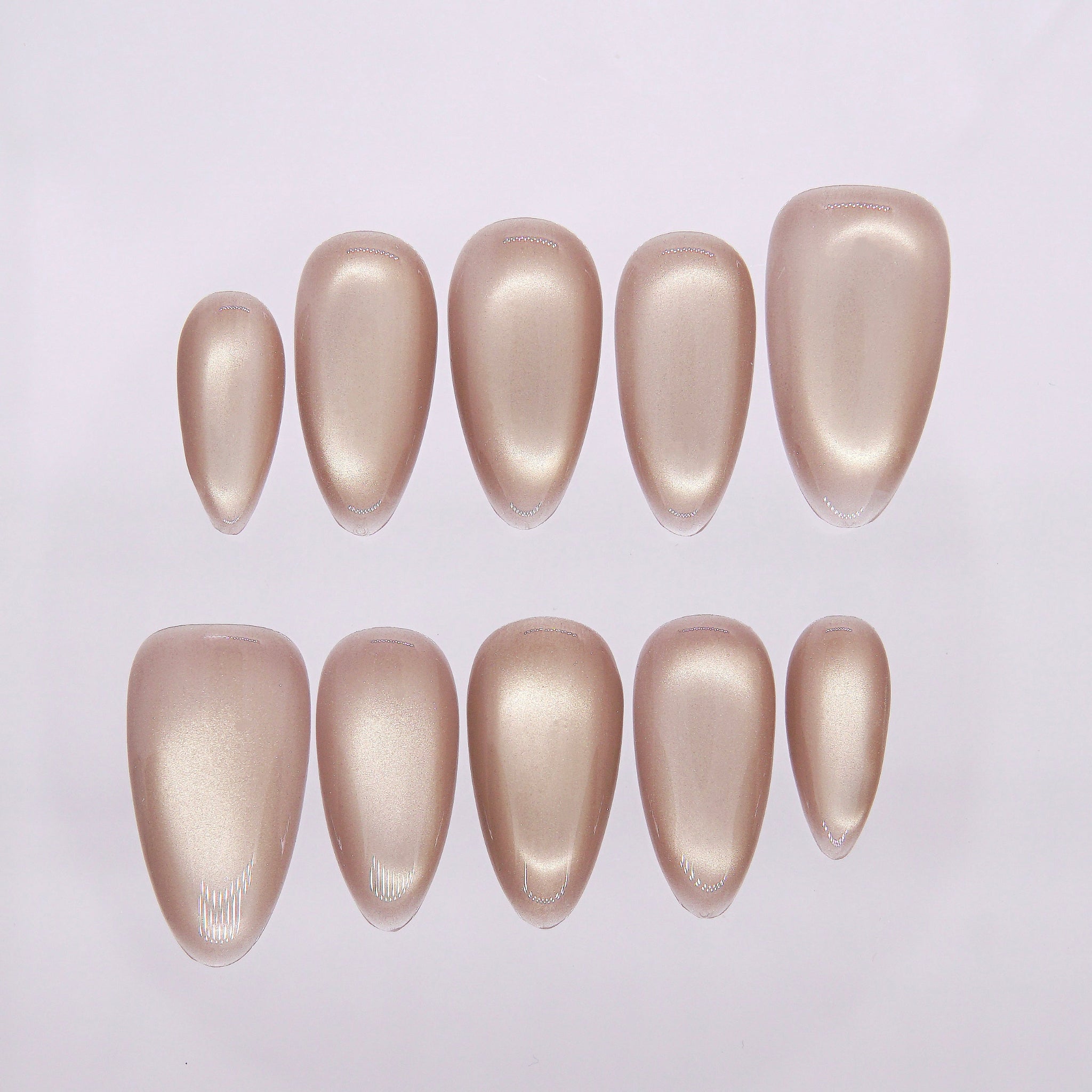 Champagne-gold cat eye press-on nails with luminous shimmer.