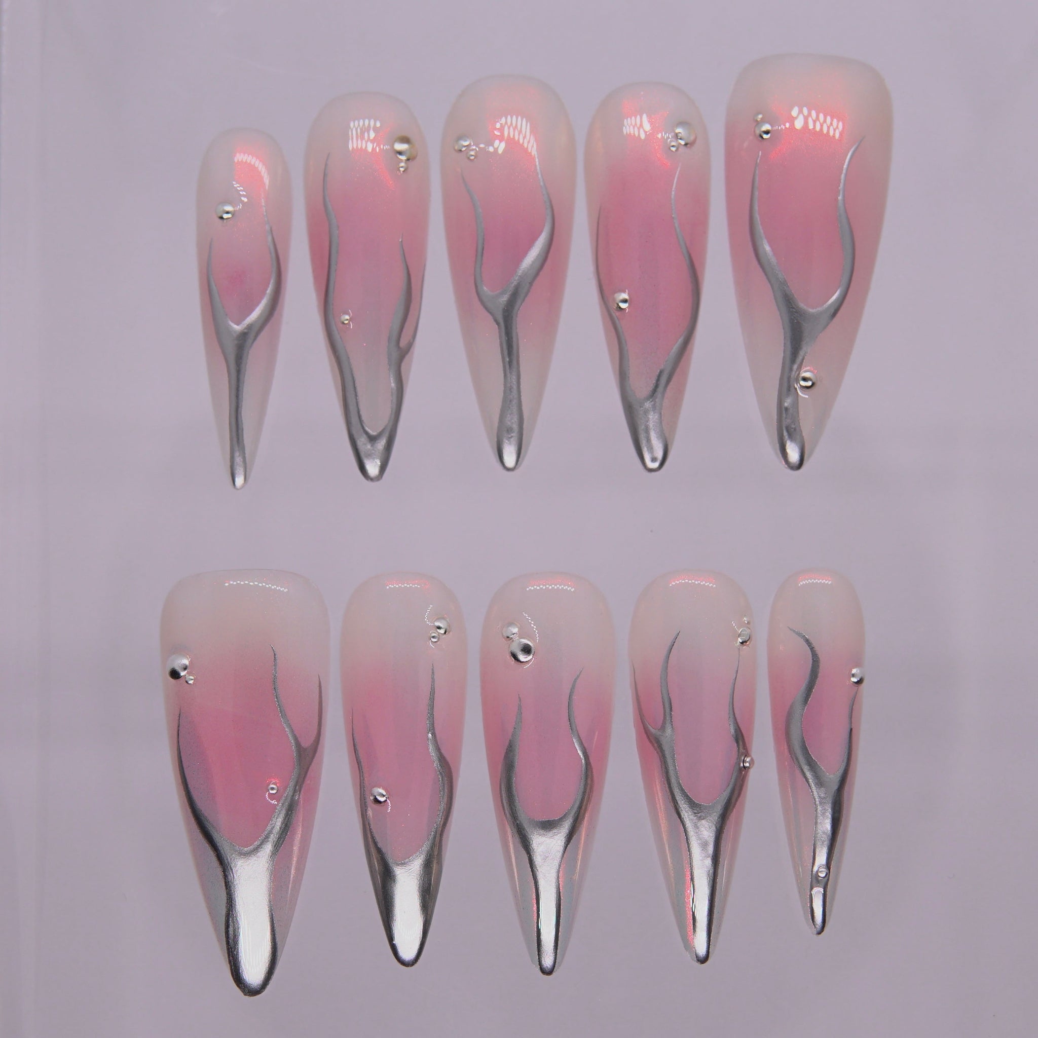 Ember Alloy press-on nails — soft pink with molten silver chrome detailing, long almond shape.