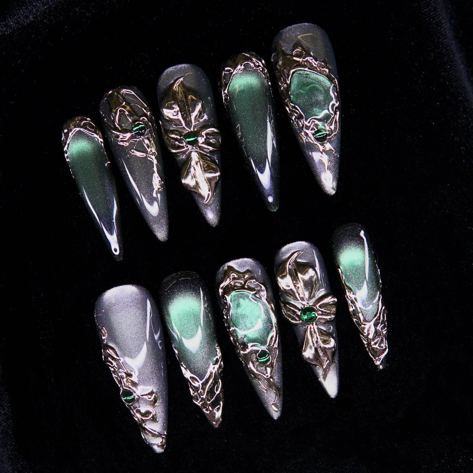 Close-up of emerald stone embedded in metallic engraving.