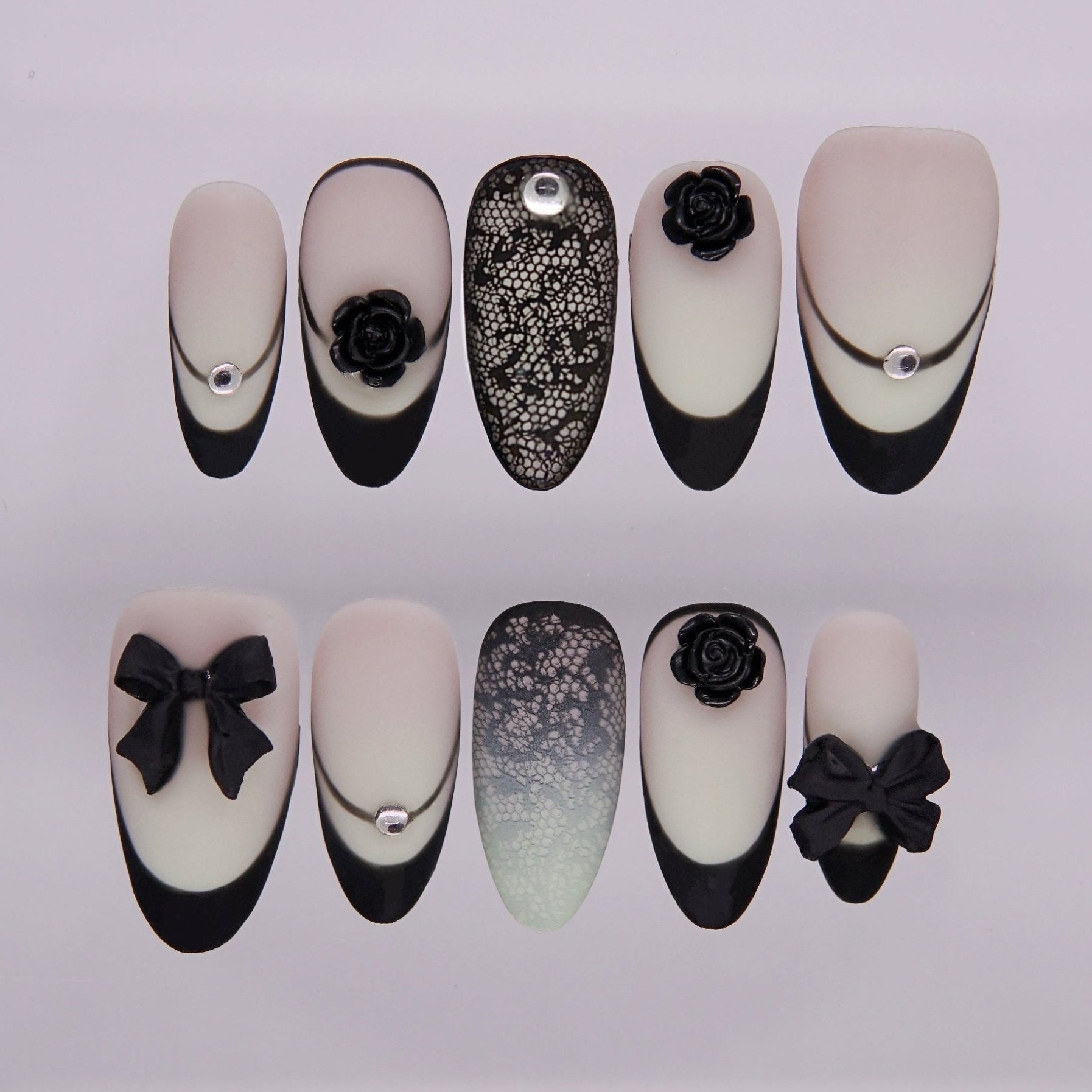 Black French tip press on nails with matte finish, lace design, and 3D rose and bow accents.