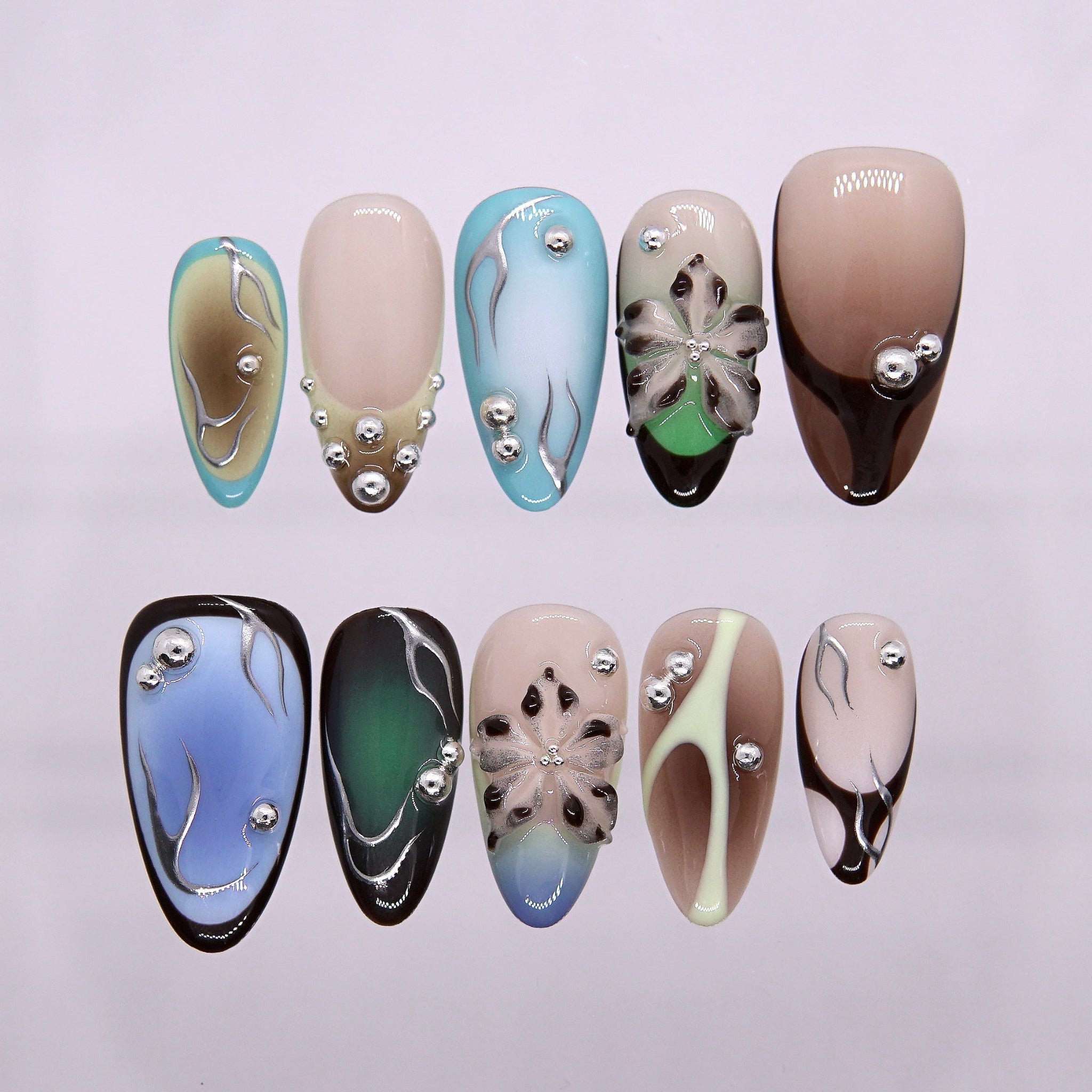 Blue-green gradient press-on nails with metallic studs.