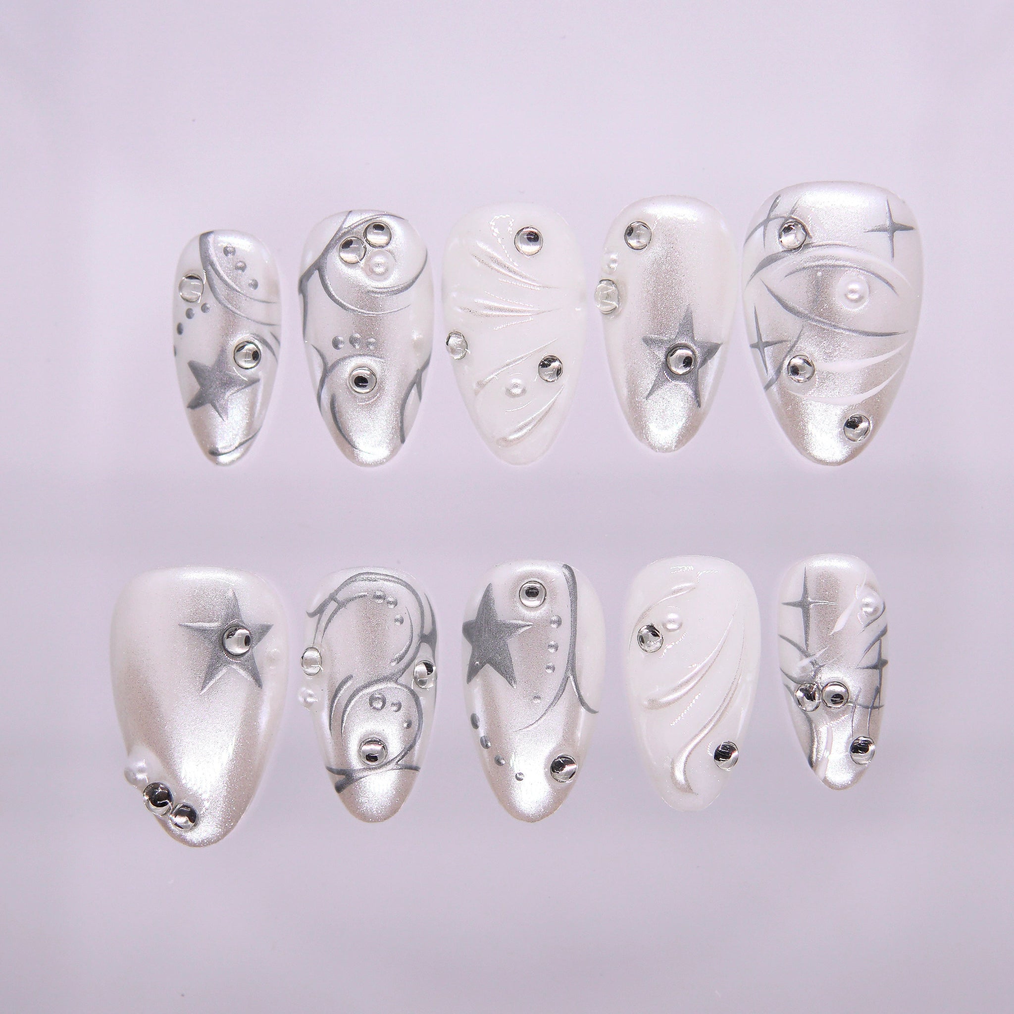 Star Circuit press-on nails with chrome silver, pearly white, and star-studded geometric details – cool Metal · Clarity design by Nailsium.