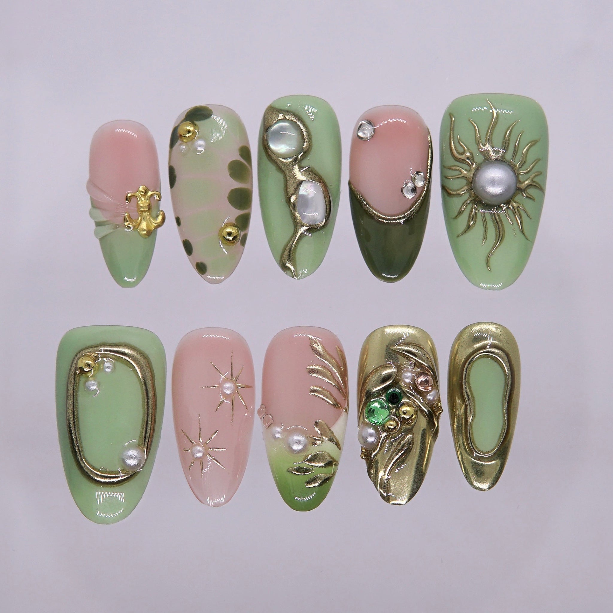 Olive green and nude press-on nails with golden starburst details.