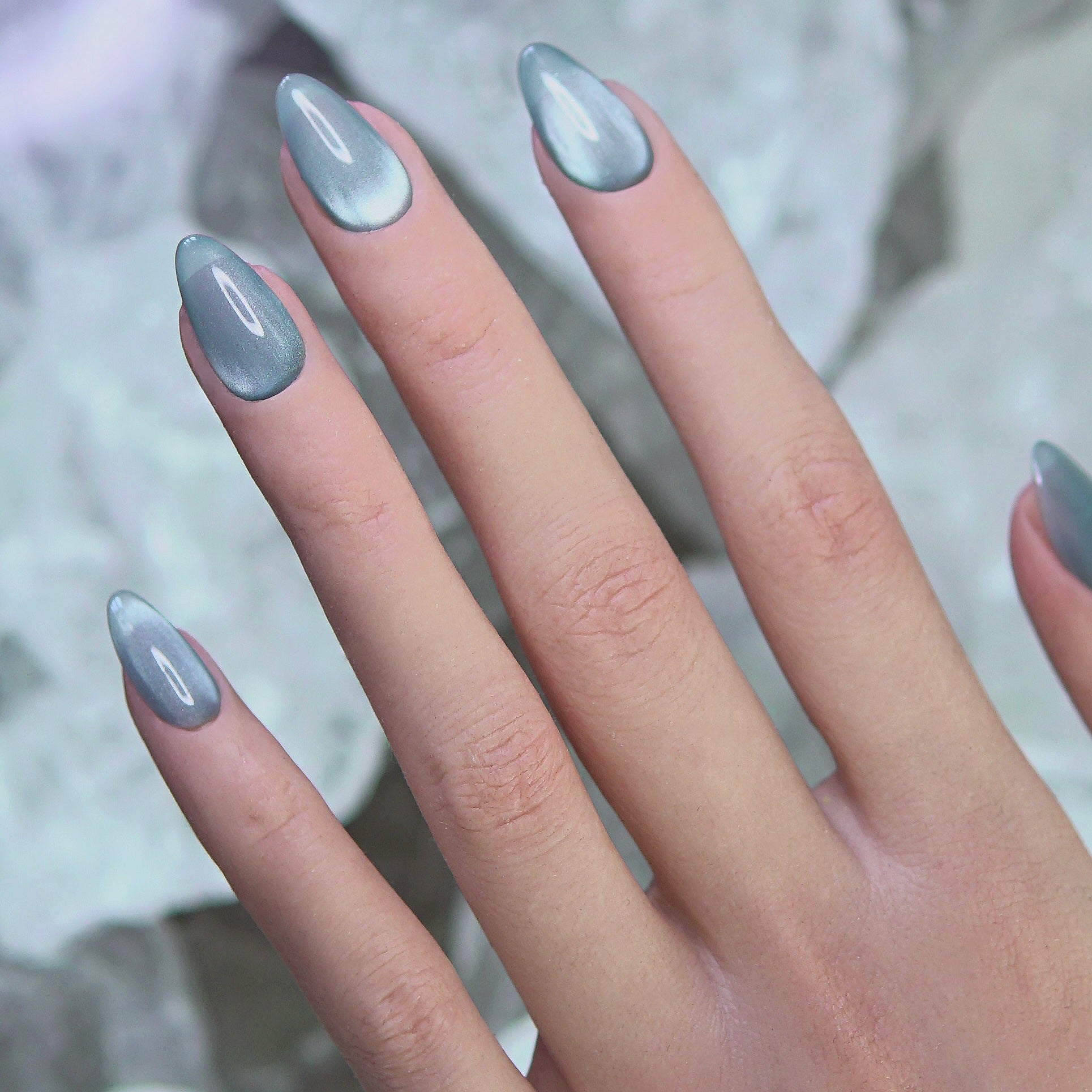 Model hand wearing Still Tide nails gently touching water surface, evoking calm and clarity.