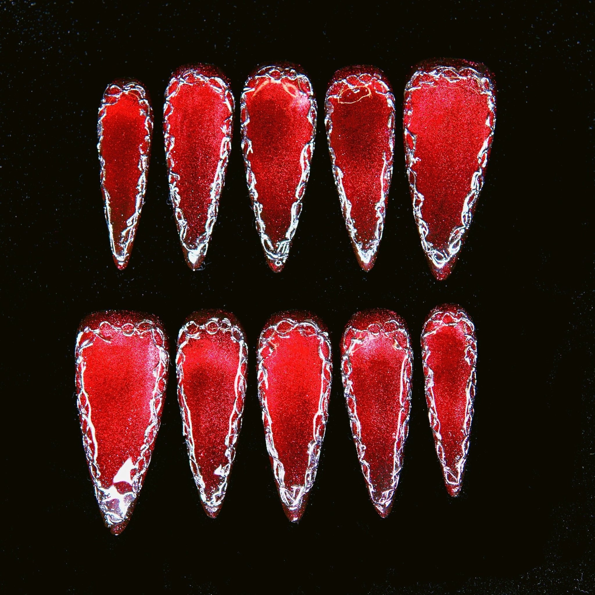 Venus Toxin press on nails — metallic red with silver chrome edges, high-shine reflective finish.
