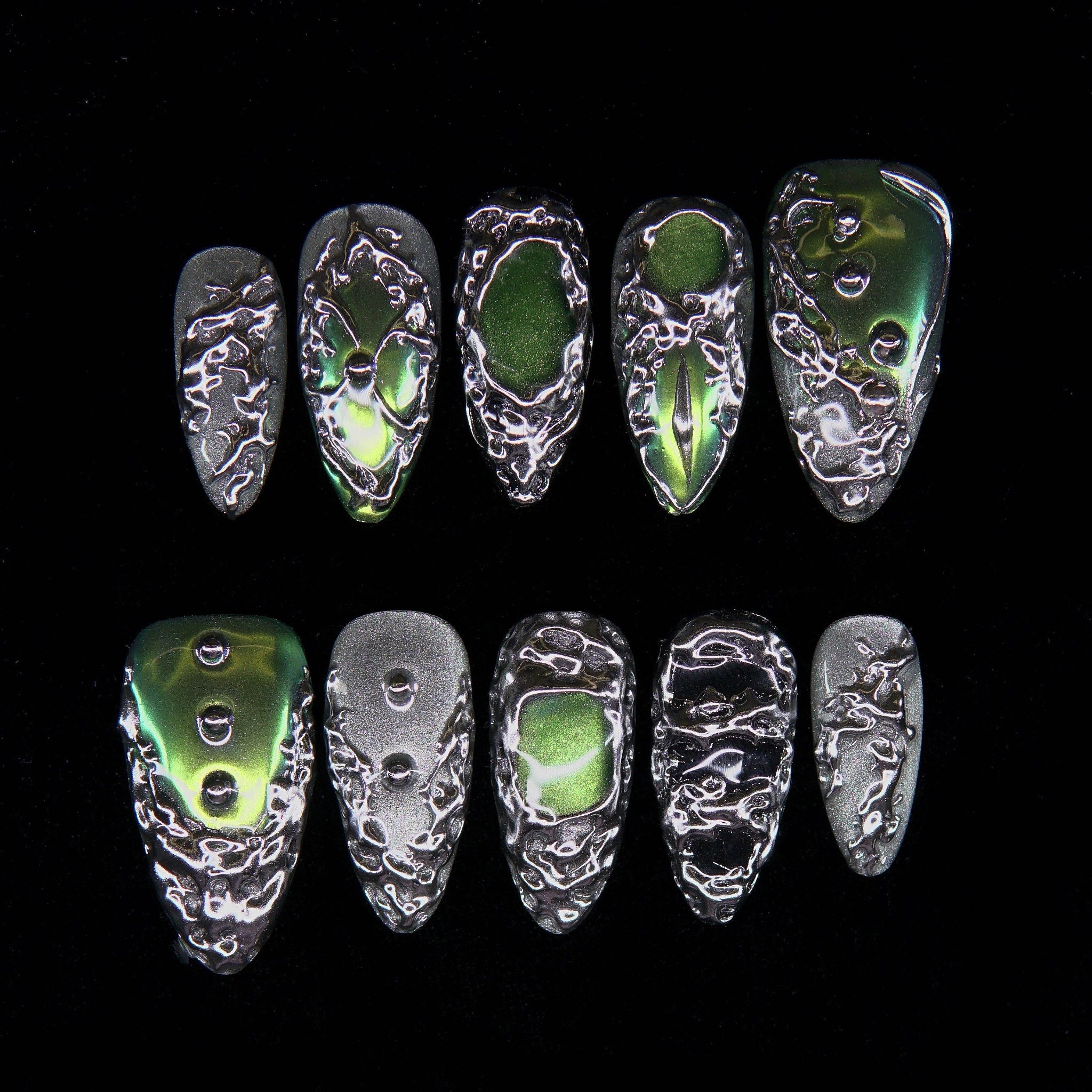 Verdant Alloy press-on nails — silver molten texture with green chrome accents.