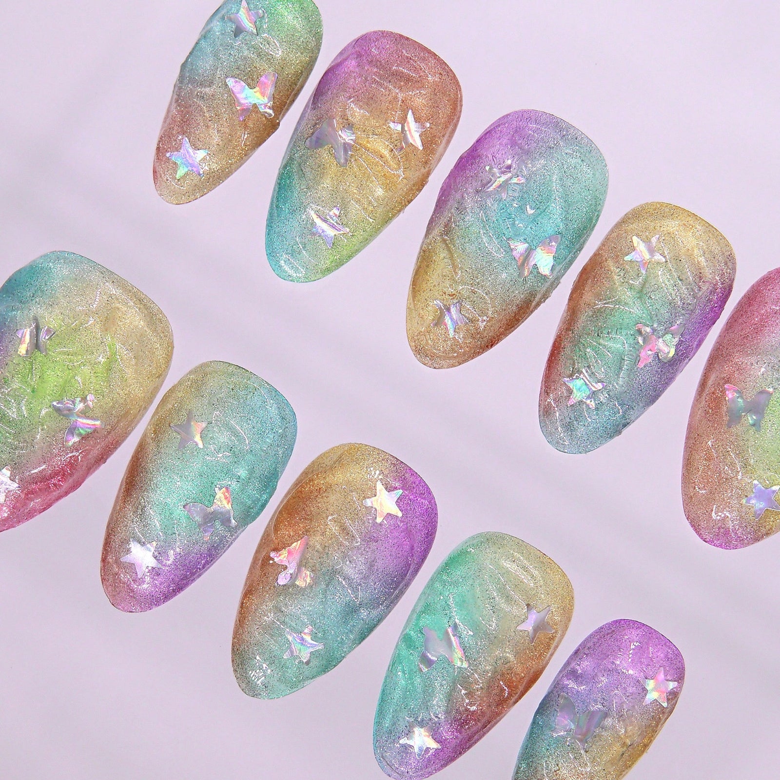 Detail of gradient shimmer finish and multicolored swirl effect on press-on nail.