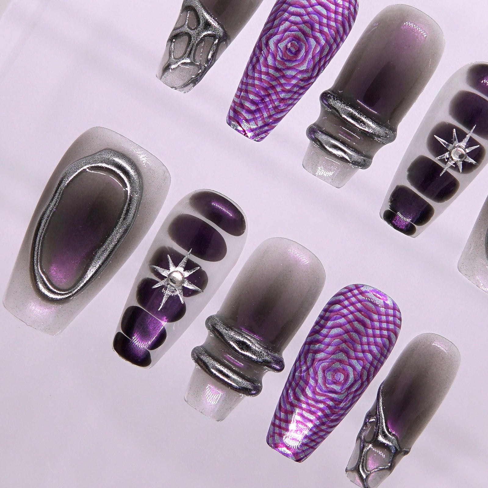Detailed view of star rhinestone embedded in black-to-violet ombre nail with light shimmer