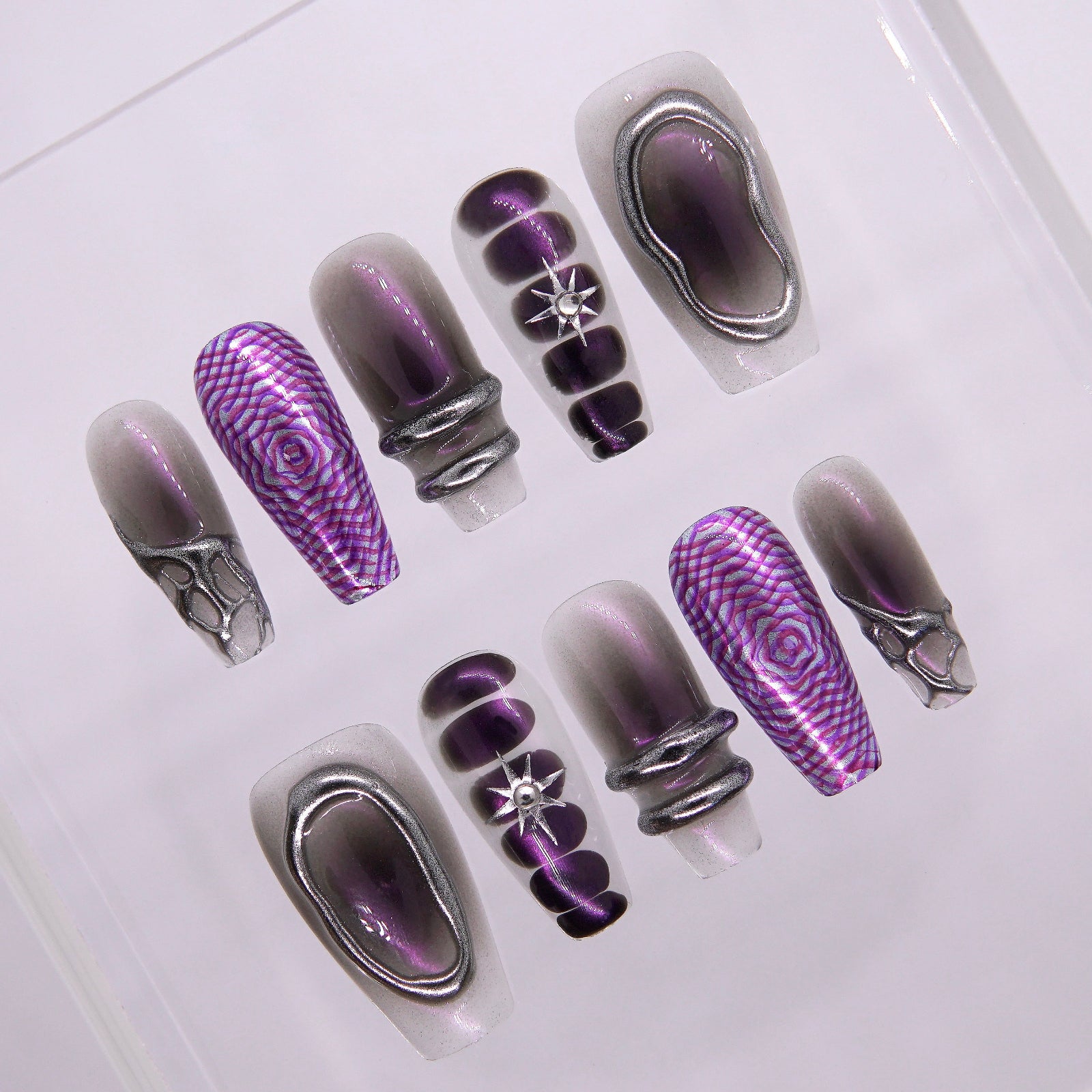 Close-up of sculpted chrome shapes and metallic purple hue on Night Bloom press-on nails