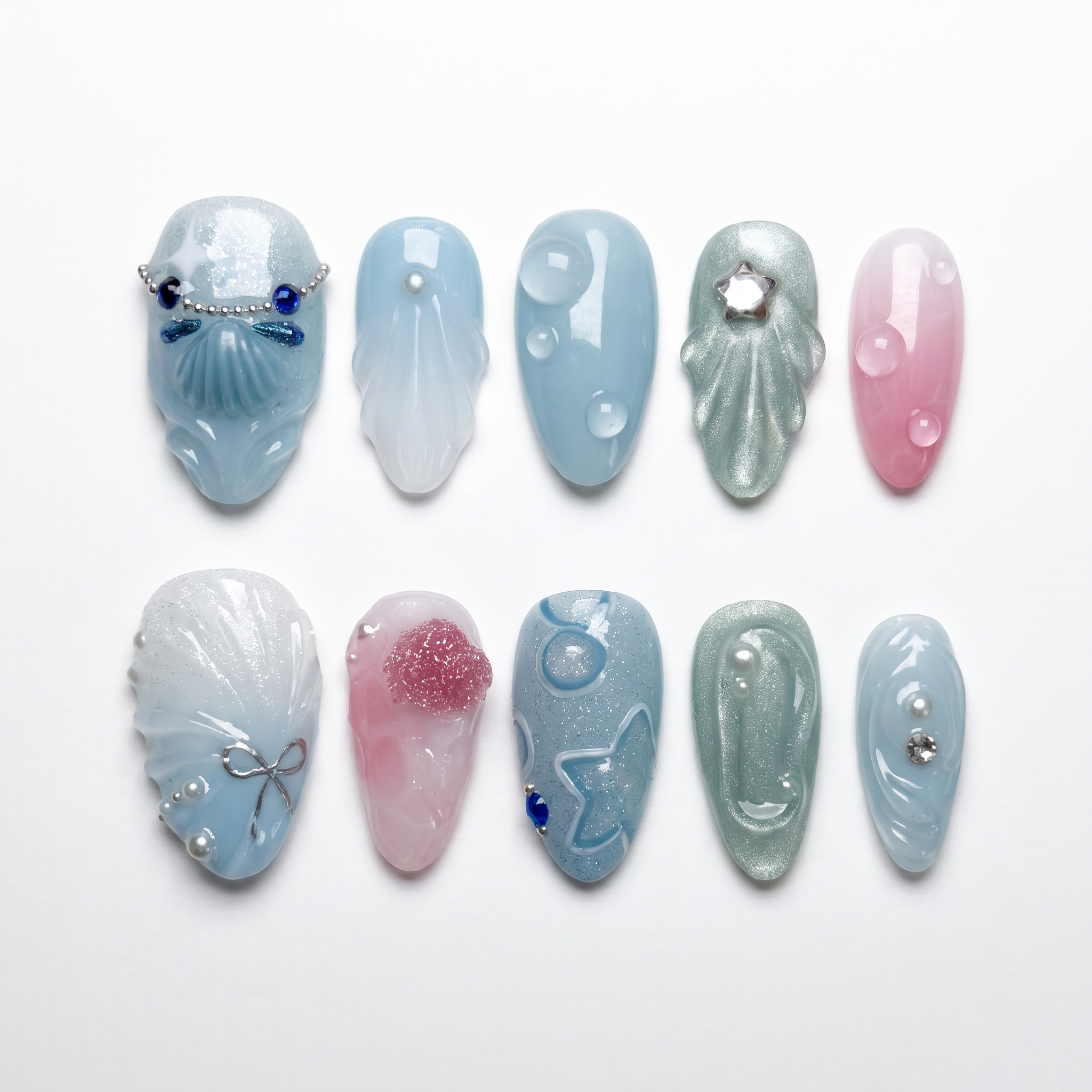 Tidepool Walk press-on nails with soft seafoam-to-pink gradient, featuring iridescent shell pieces, silver star glitters, and water droplet accents — part of the La Jolla · Water · Flow collection.