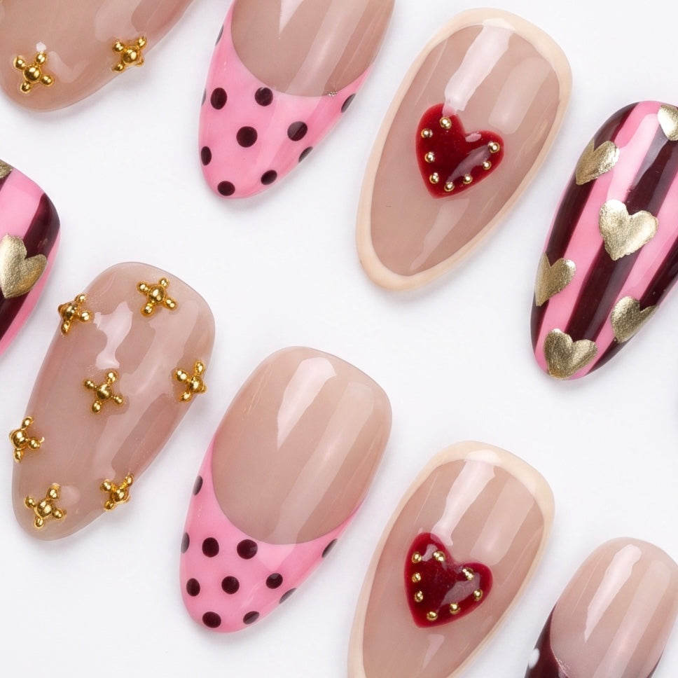 Detail view of Horse zodiac Valentine nails showing blush nude base with heart motifs, dotted tips, and expressive color contrasts.