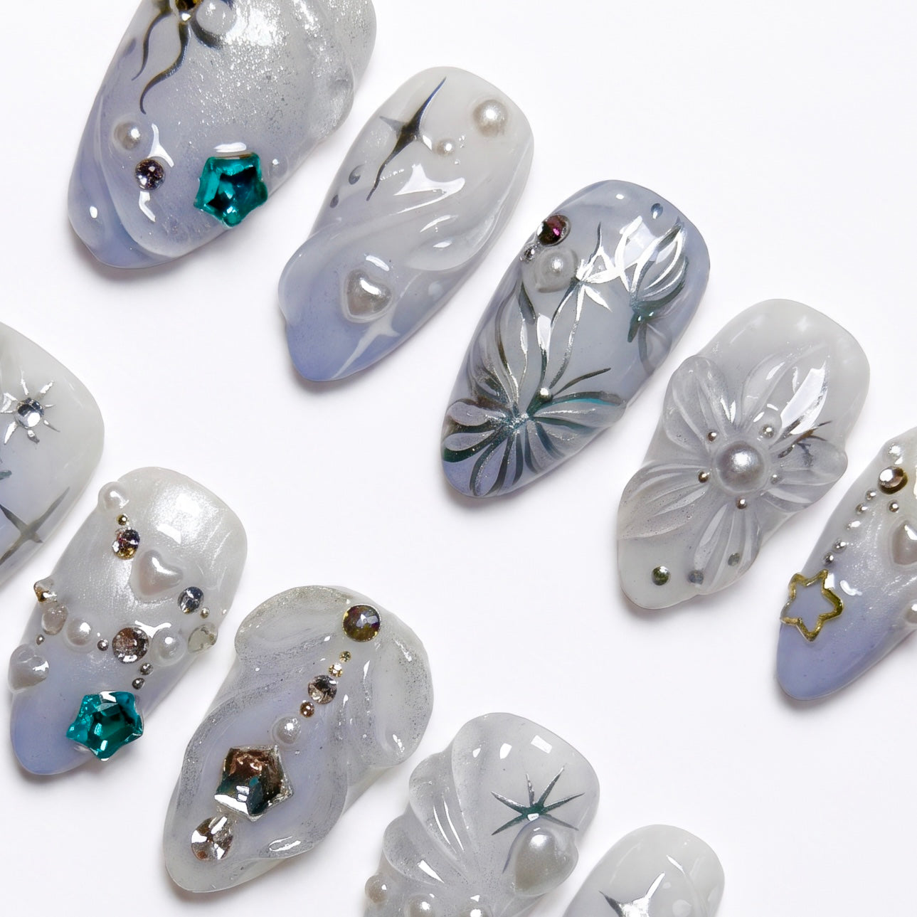 Soft pearly white and icy blue press-on nails with glowing pearls and glitter accents.