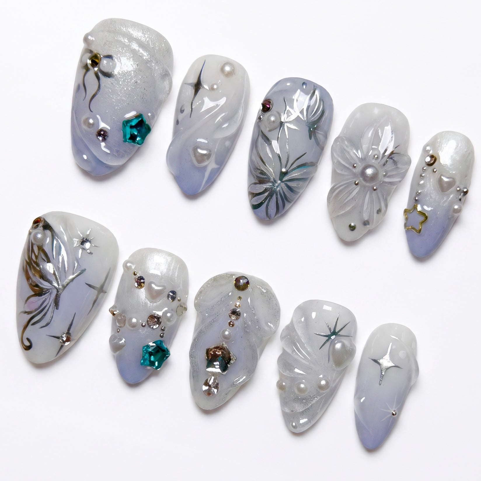 Close-up of silver butterfly wings and star trails on icy blue press-on nails.