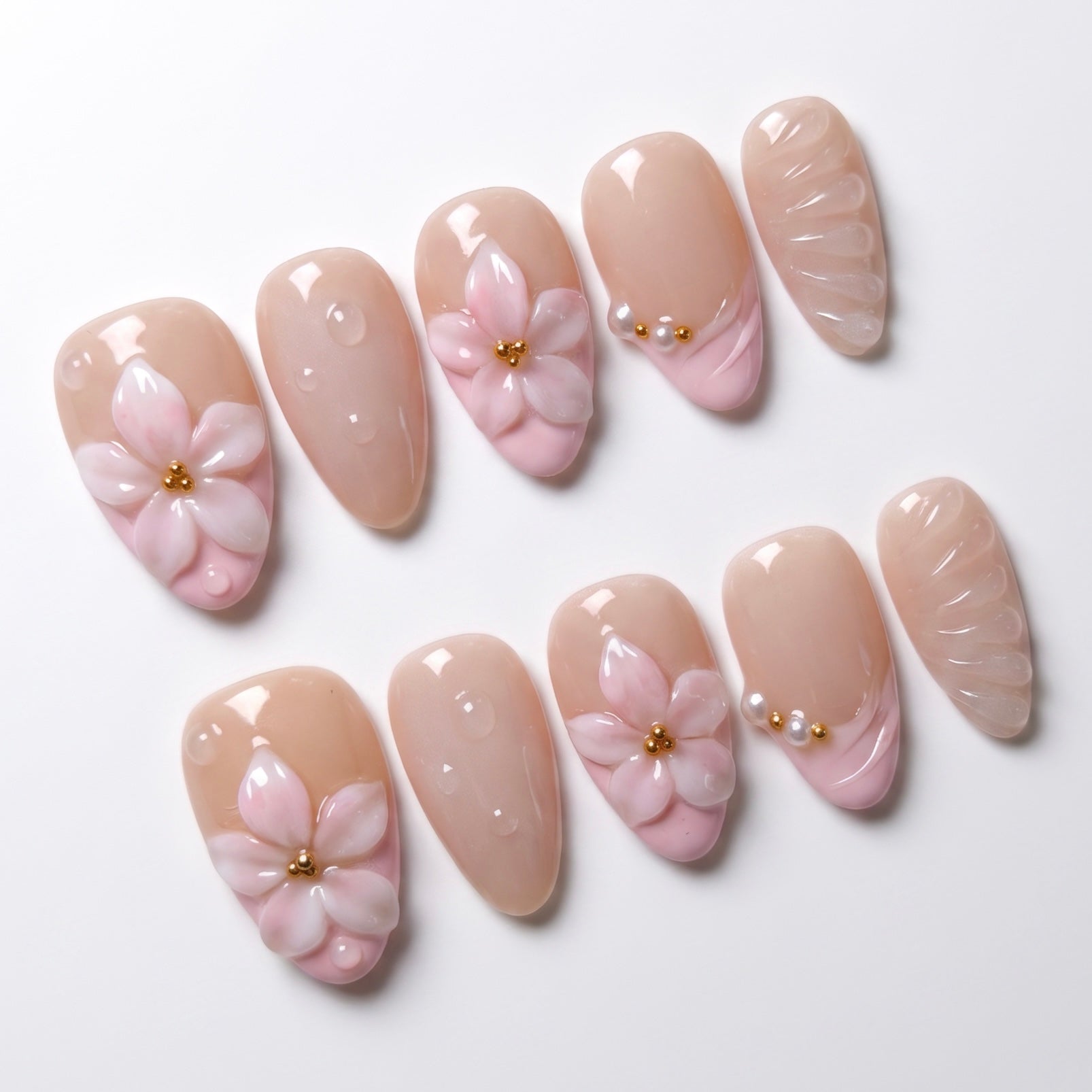 Close up of sculpted pink 3D flower nail with gold bead detail and glossy finish.