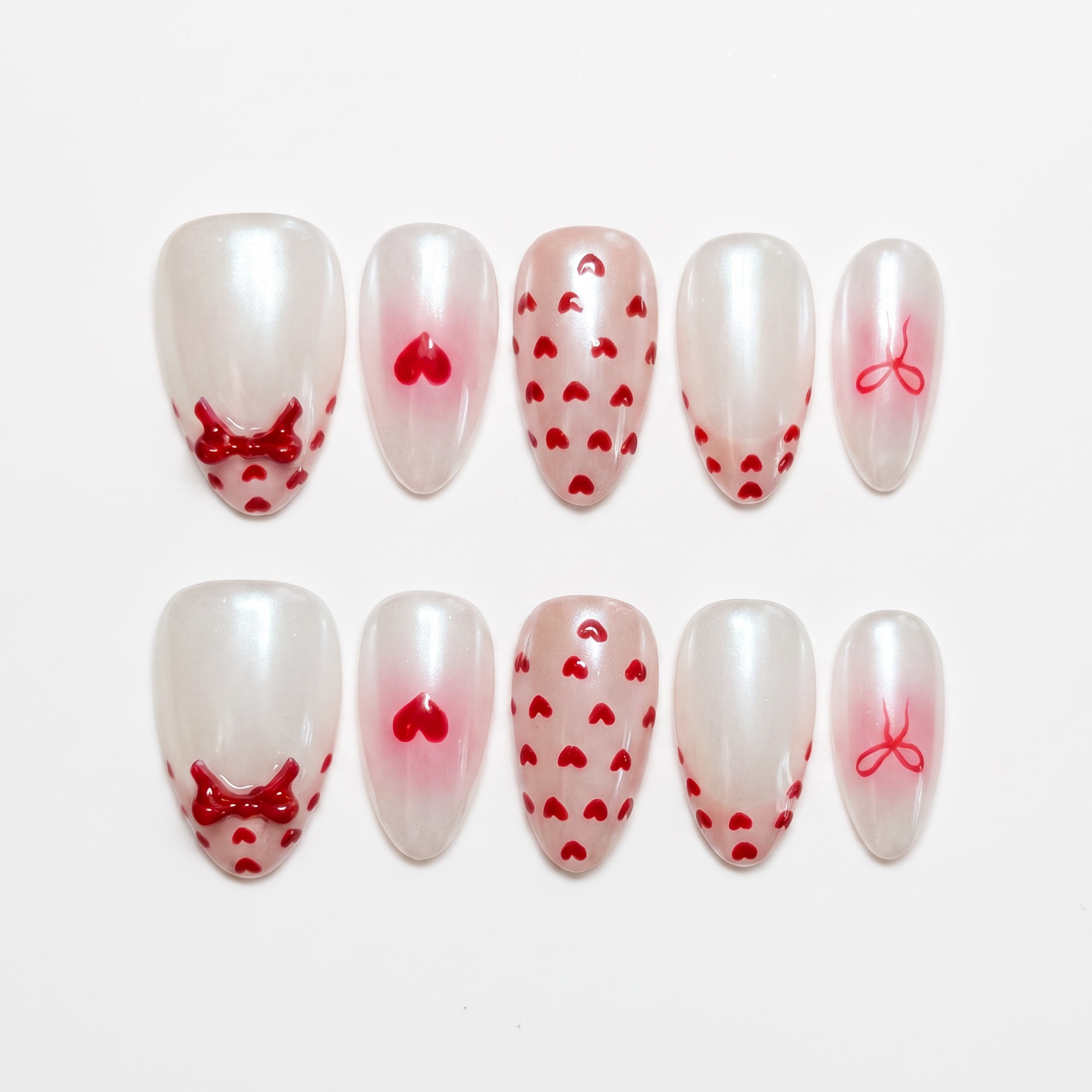 Goat zodiac press-on nails in milky white with red heart and bow details, representing Serene self love and emotional calm.