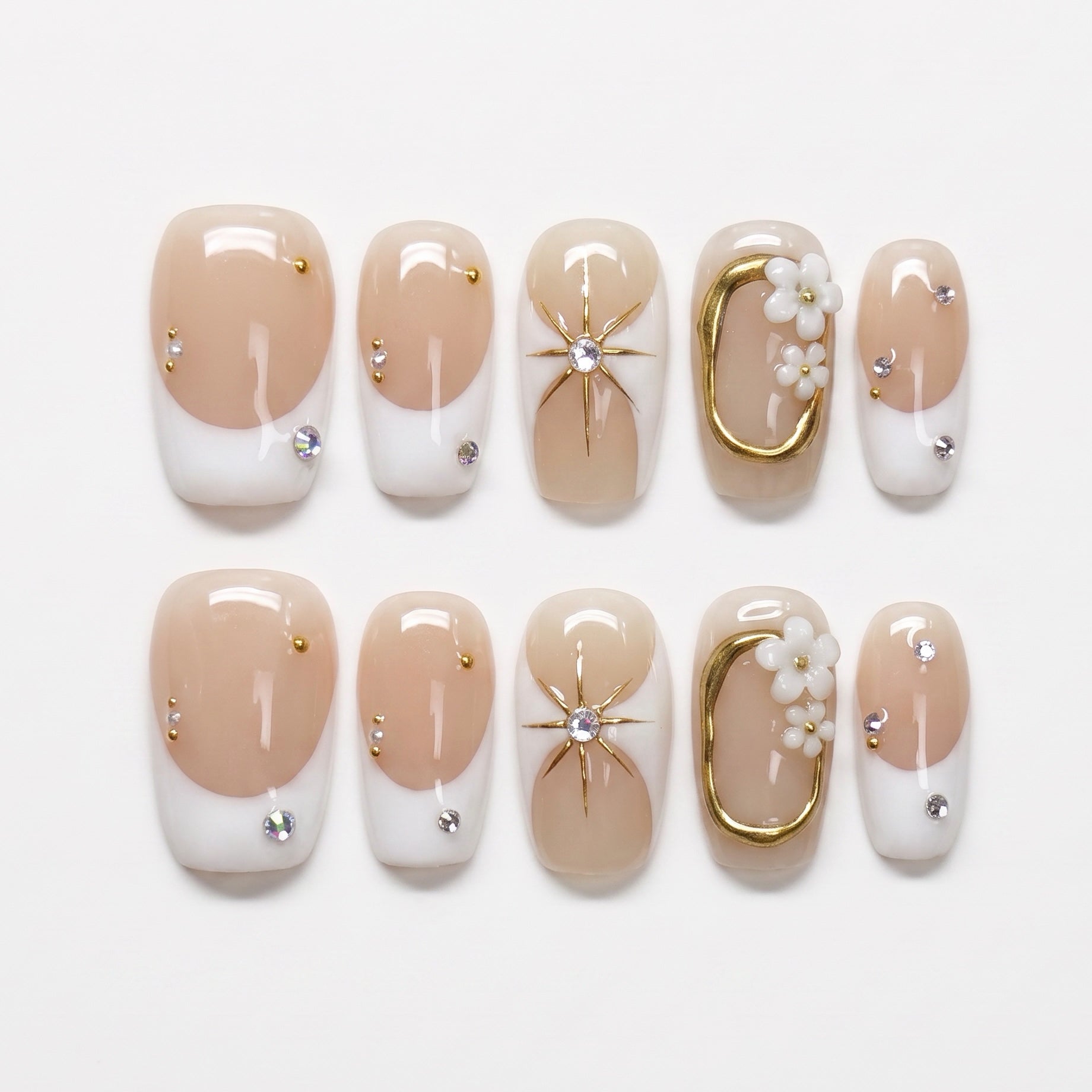 Nude and white press on nails with minimalist gold accents and clean design