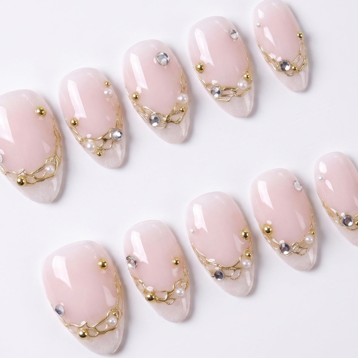 Close-up of neutral nails with fine gold detailing and glossy finish