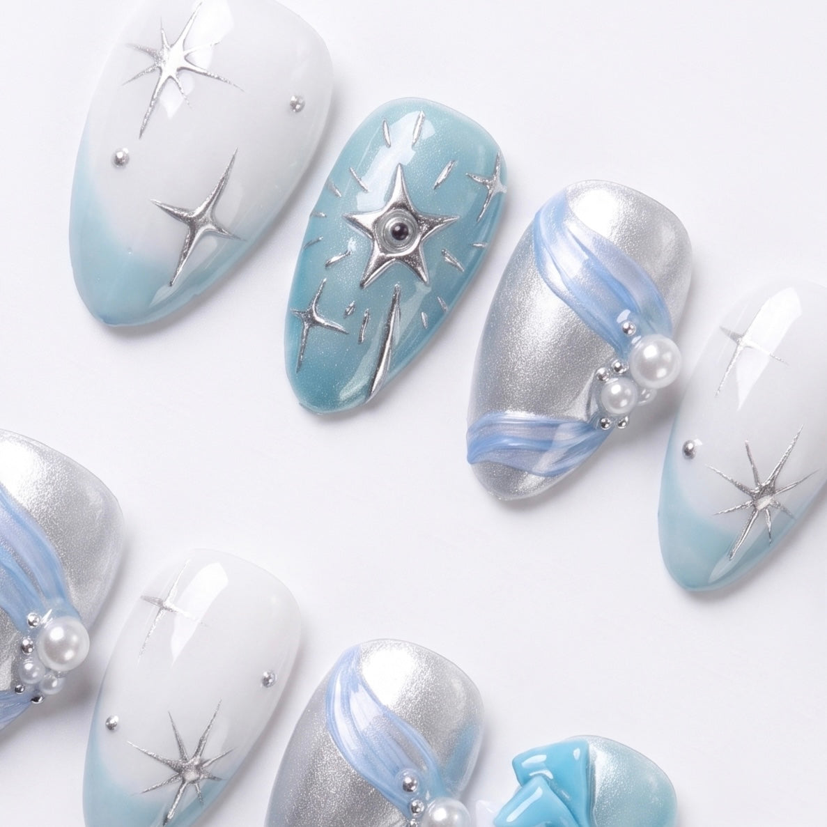 Dreamy nail art with light blue tones, glossy texture, and subtle sparkle