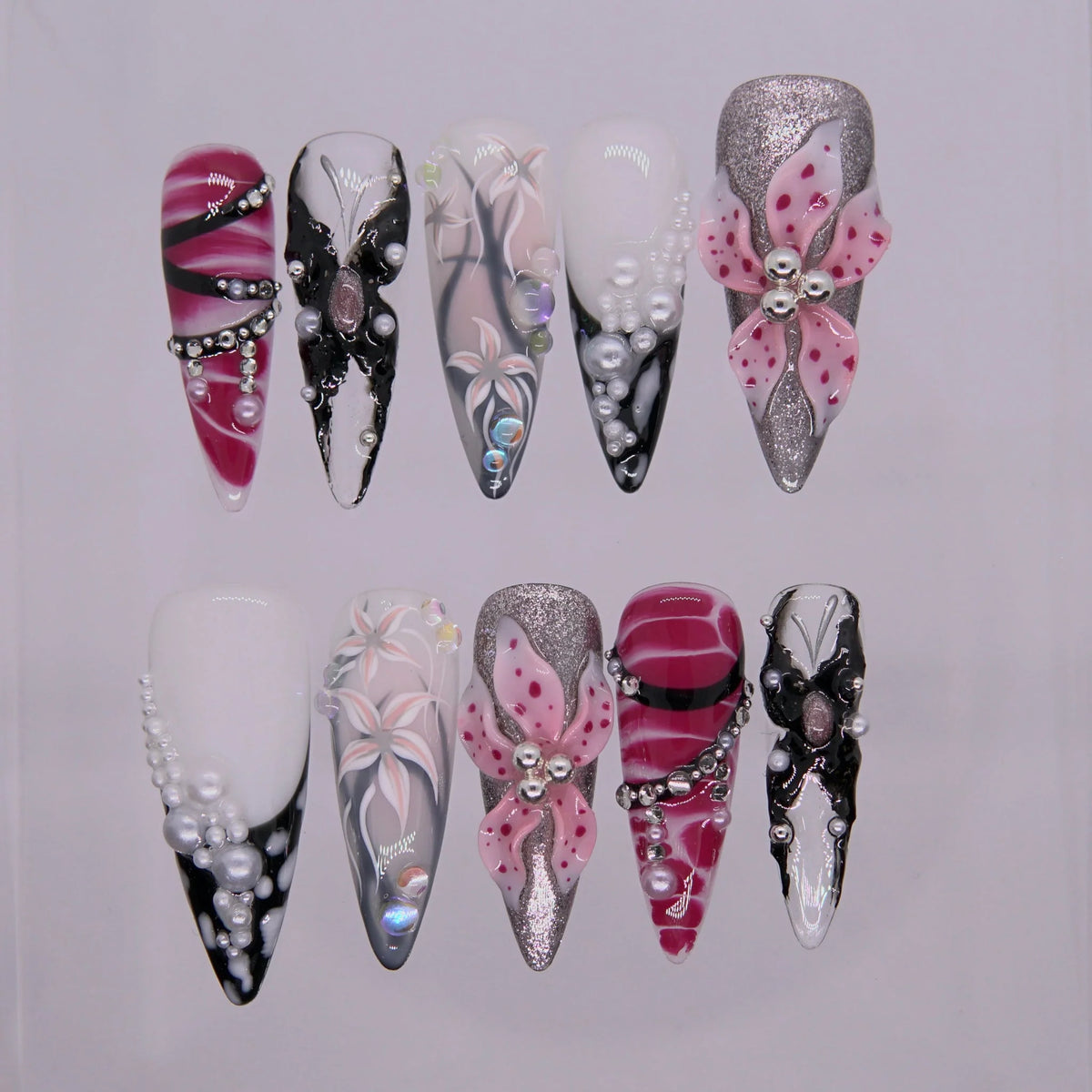 Obsidian Bloom press on nails — black gloss with white 3D blossoms and pearl detailing, inspired by emotional alchemy.