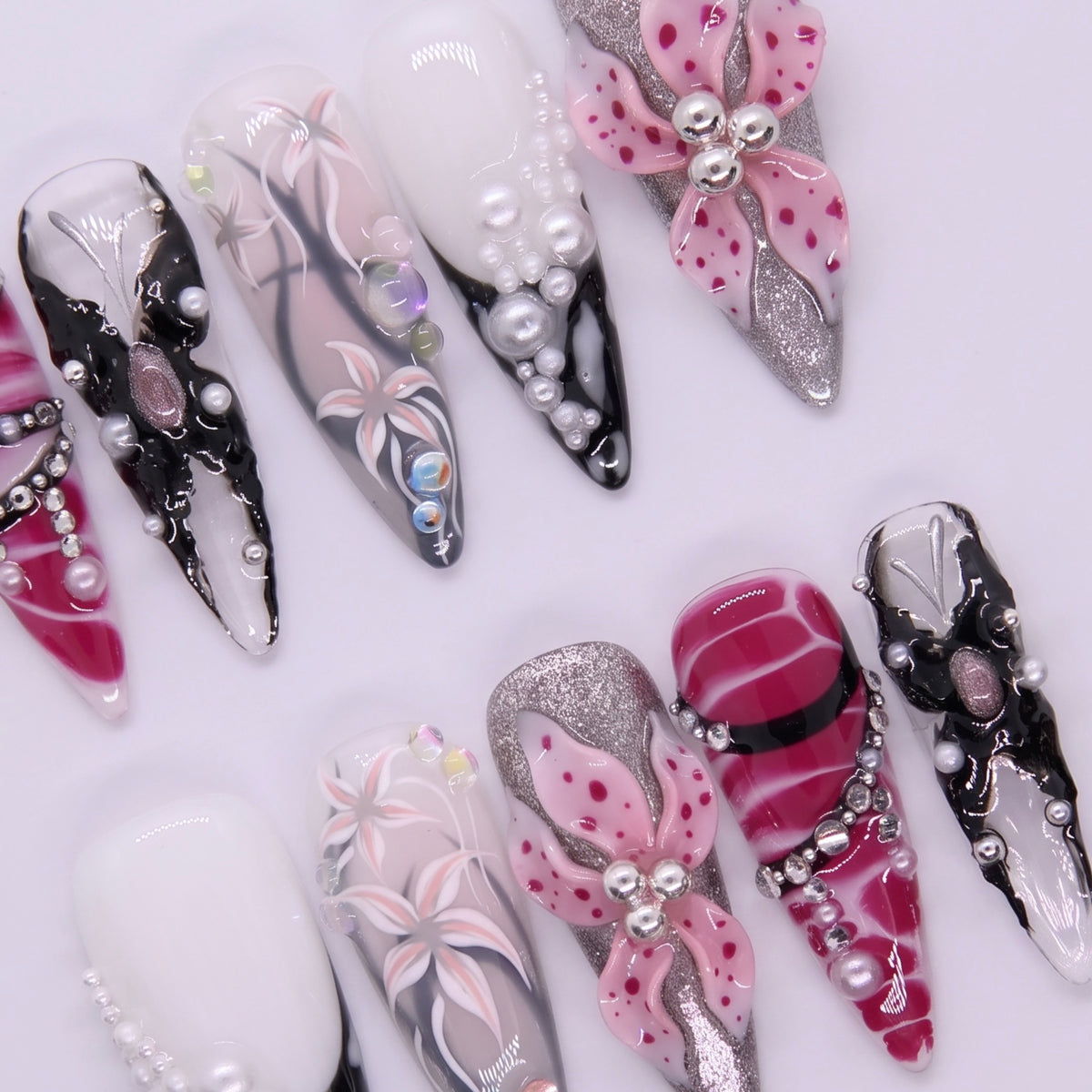 Close-up of handcrafted pearl and flower textures on Obsidian Bloom nails.
