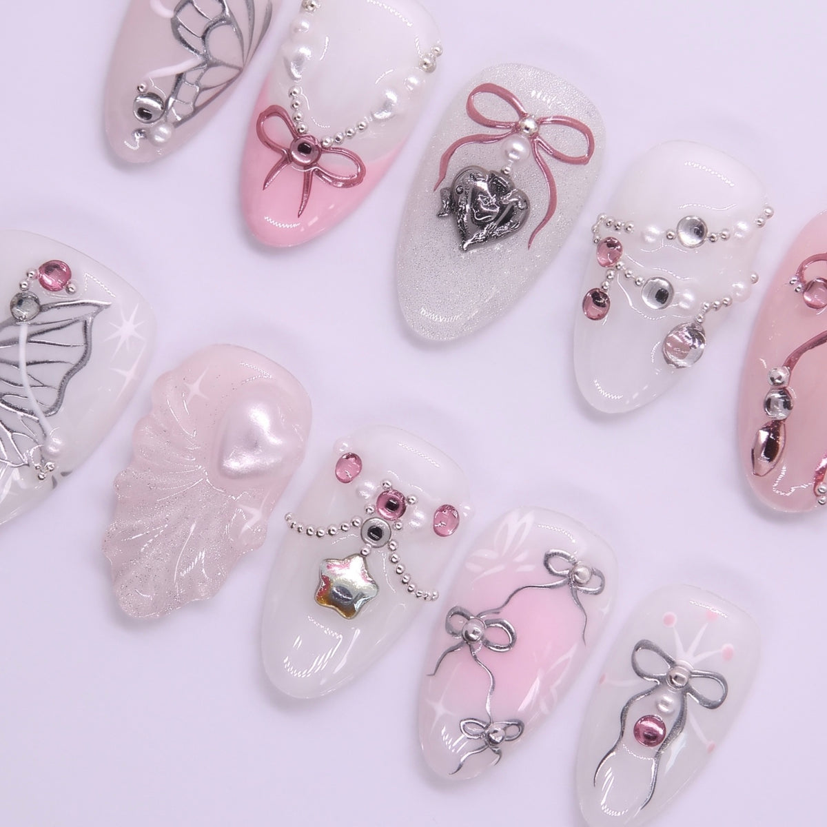 Close-up of ribbon nail design with pearl accents and soft blush tones.