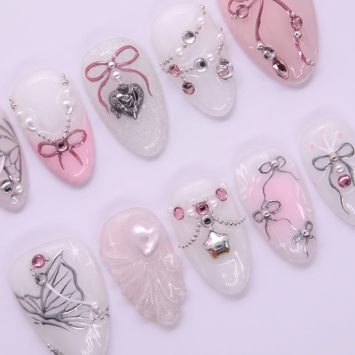 Close-up of ribbon nail design with pearl accents and soft blush tones.