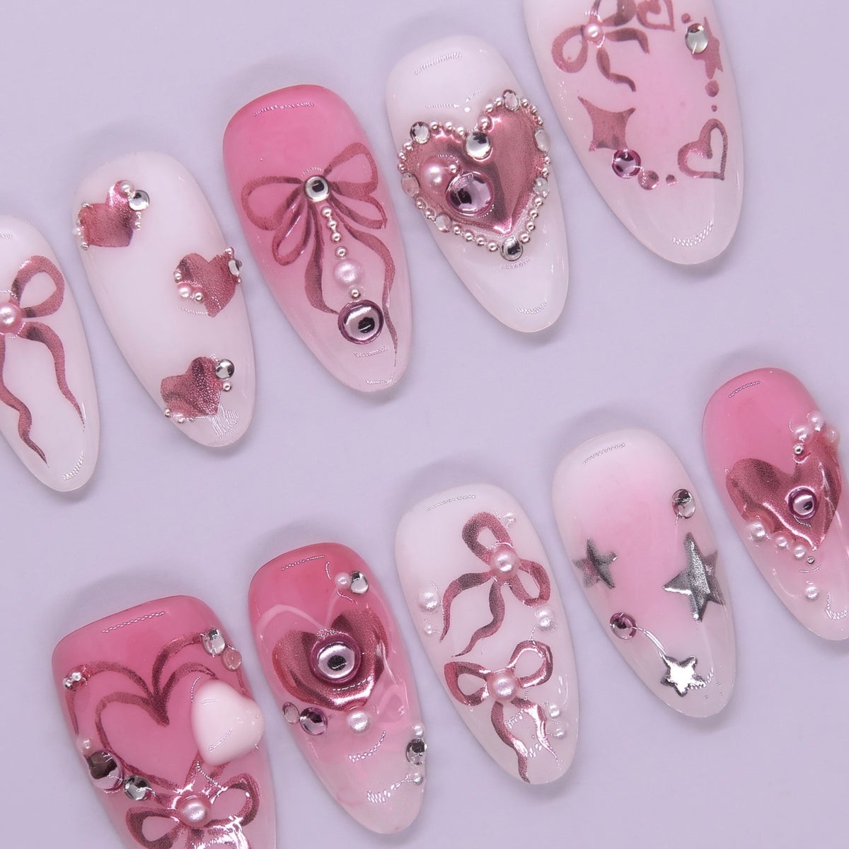 Metallic pink heart press on nails with star details and glossy finish.
