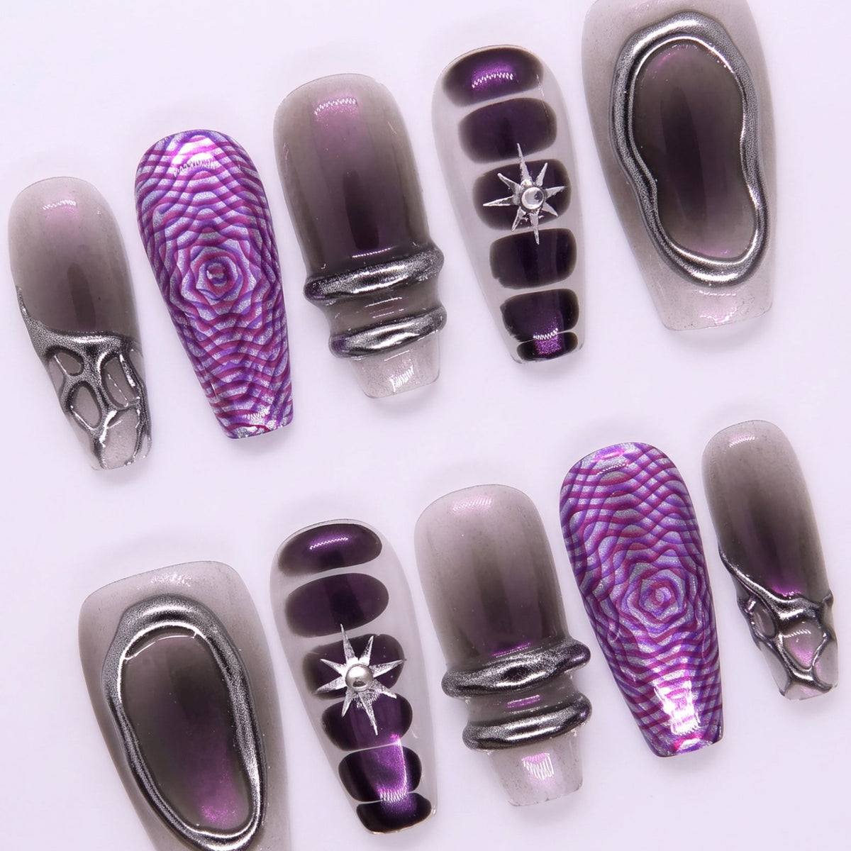 Detailed view of star rhinestone embedded in black-to-violet ombre nail with light shimmer