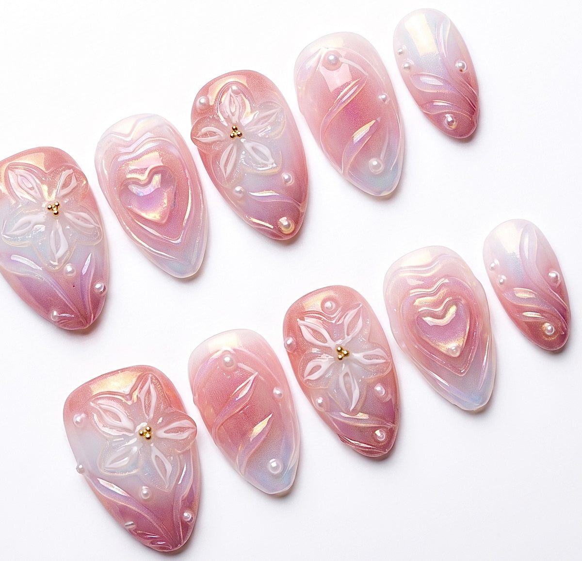 Detailed view of 3D heart centerpiece with shimmer finish on soft girl press-on nails.