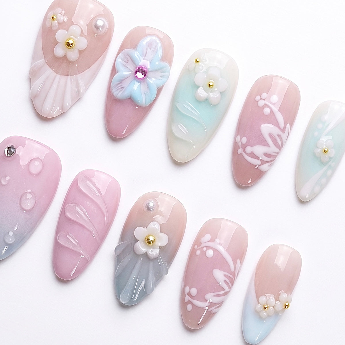 Close-up of pearly flowers and shell details on pastel press-on nails with soft glossy finish.