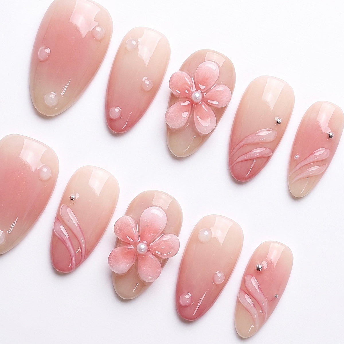 Glossy nude-pink press-on nails with soft water-like dew-drop details for a fresh, natural vibe.