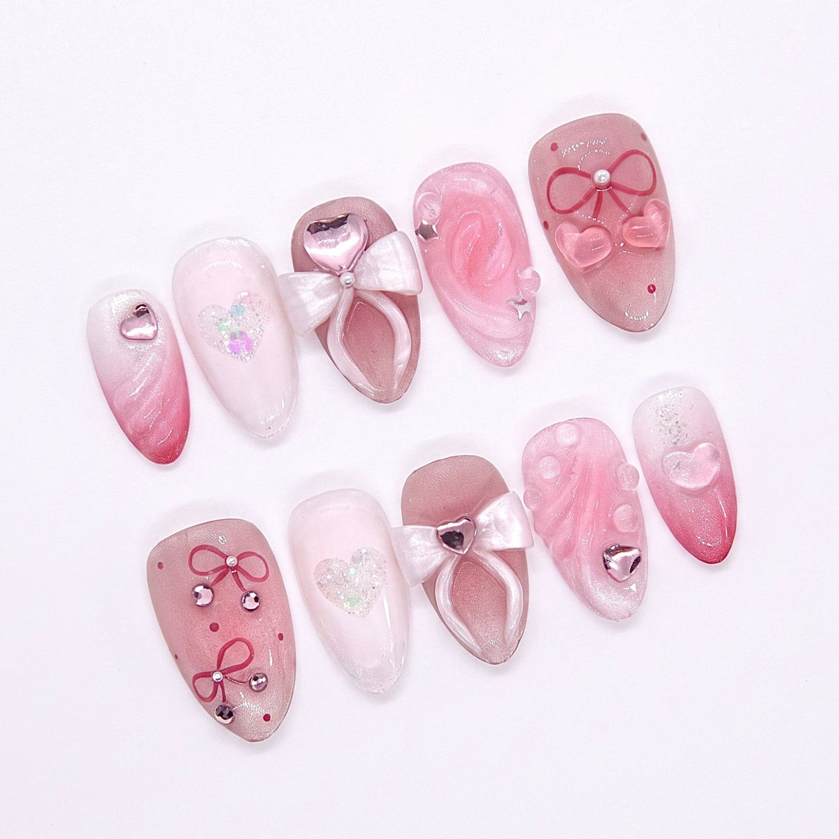 Close-up of 3D white bow on a blush pink nail, with heart gem accent and pearly finish.