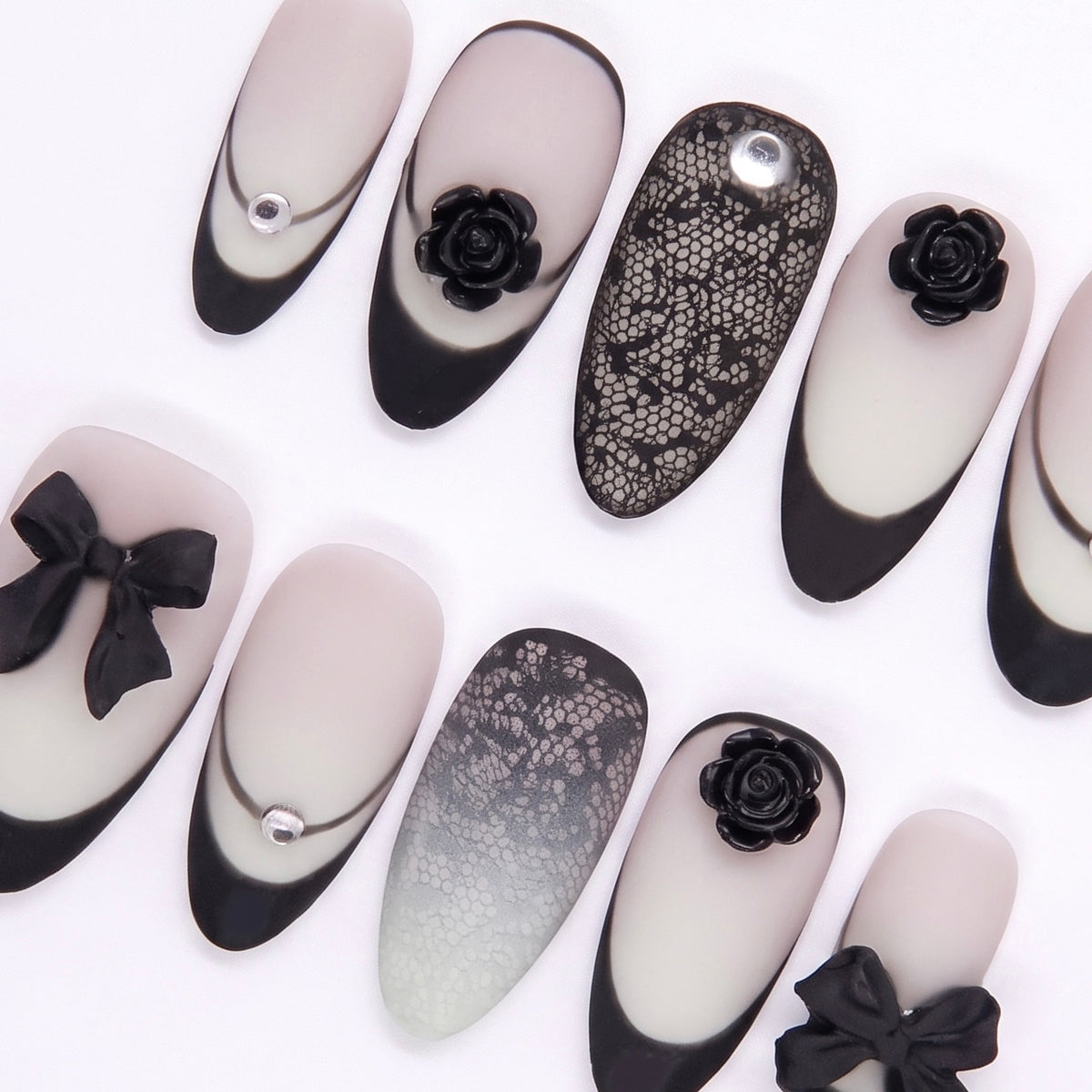Matte gradient press on nails decorated with black roses and bows.