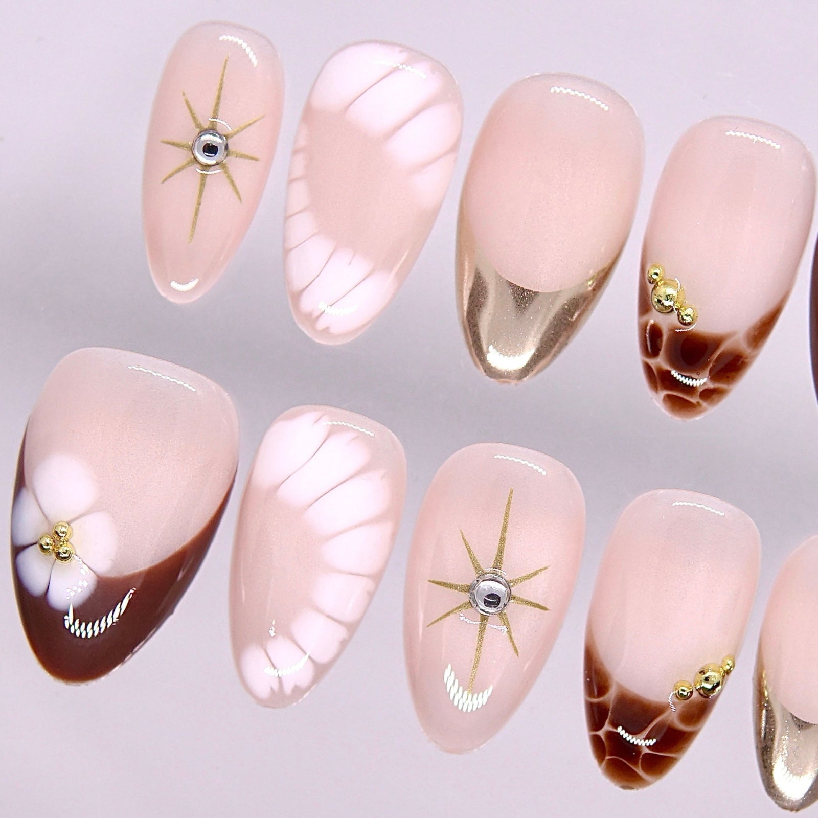 Detail view of Begin at Heart press-on nails highlighting warm brown accents and delicate gold embellishments