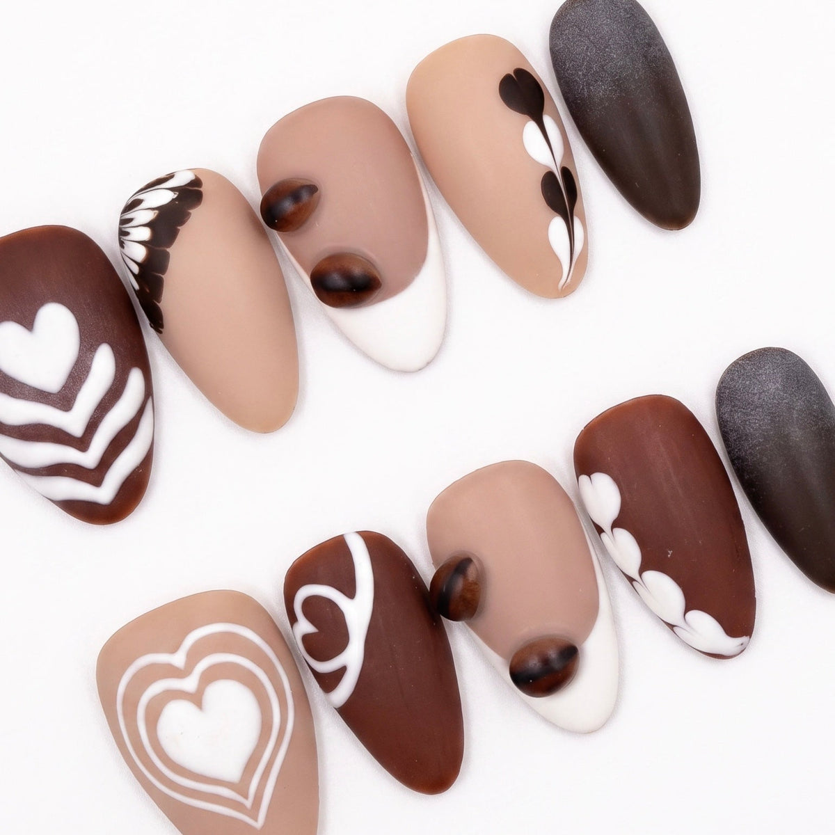 Close-up of Begin with Care press-on nails showing latte art patterns inspired by coffee foam designs