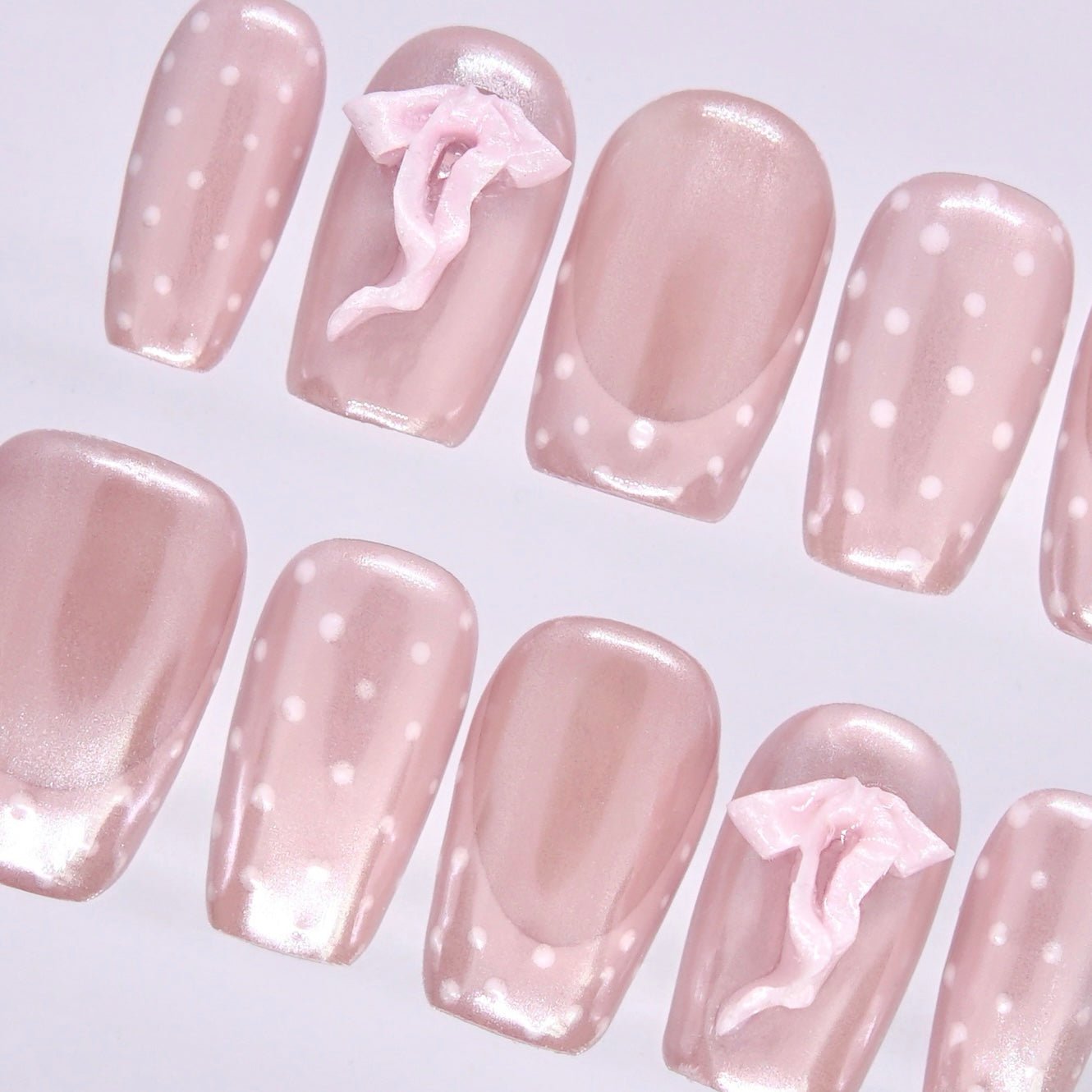 Detail view of Pig zodiac Valentine nails showing translucent pink sheen, dotted pattern placement, and bow accent nails.
