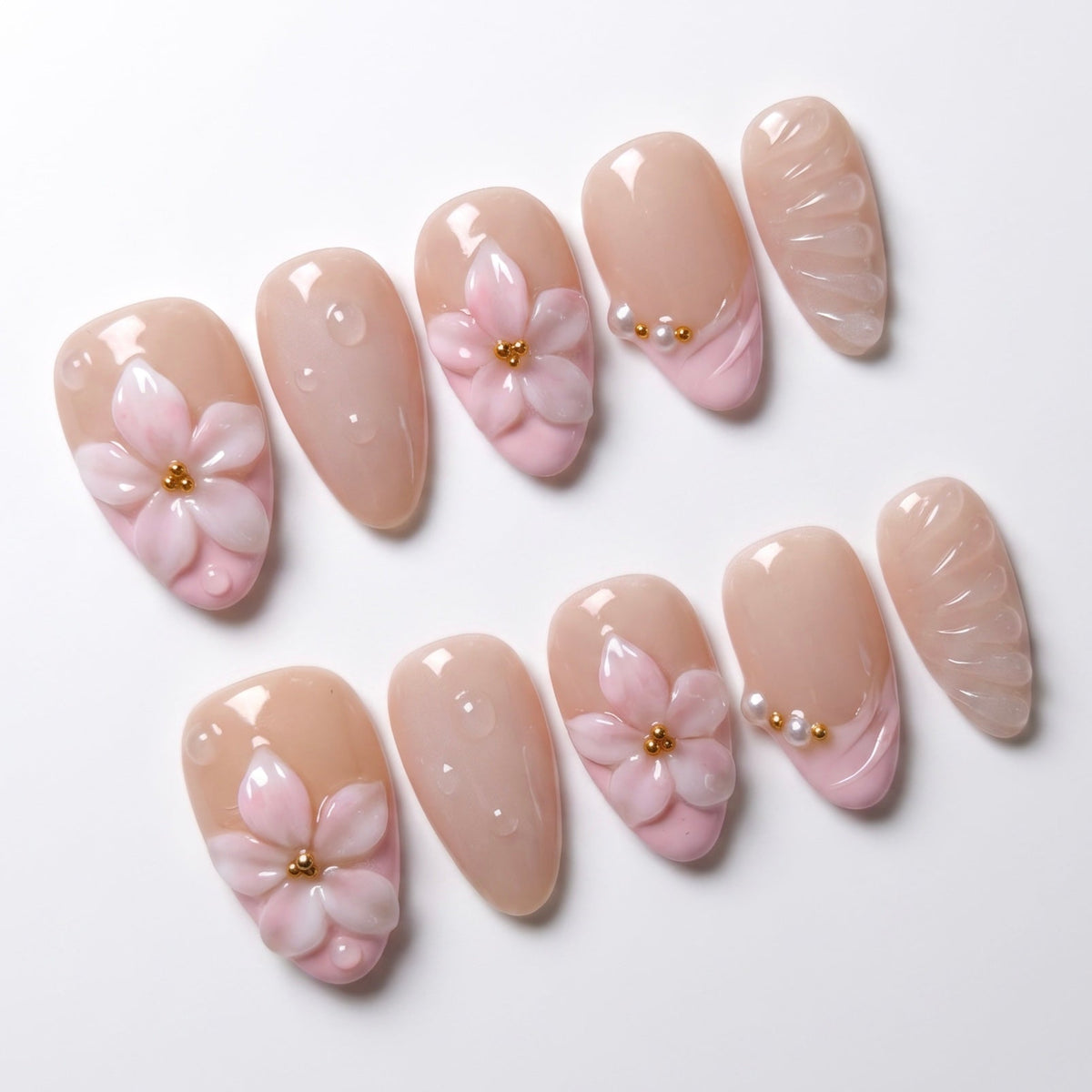 Close up of sculpted pink 3D flower nail with gold bead detail and glossy finish.