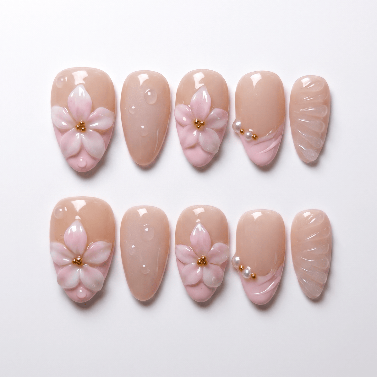 Pink 3D flower press on nails with blush French tip and gold bead center on nude base.