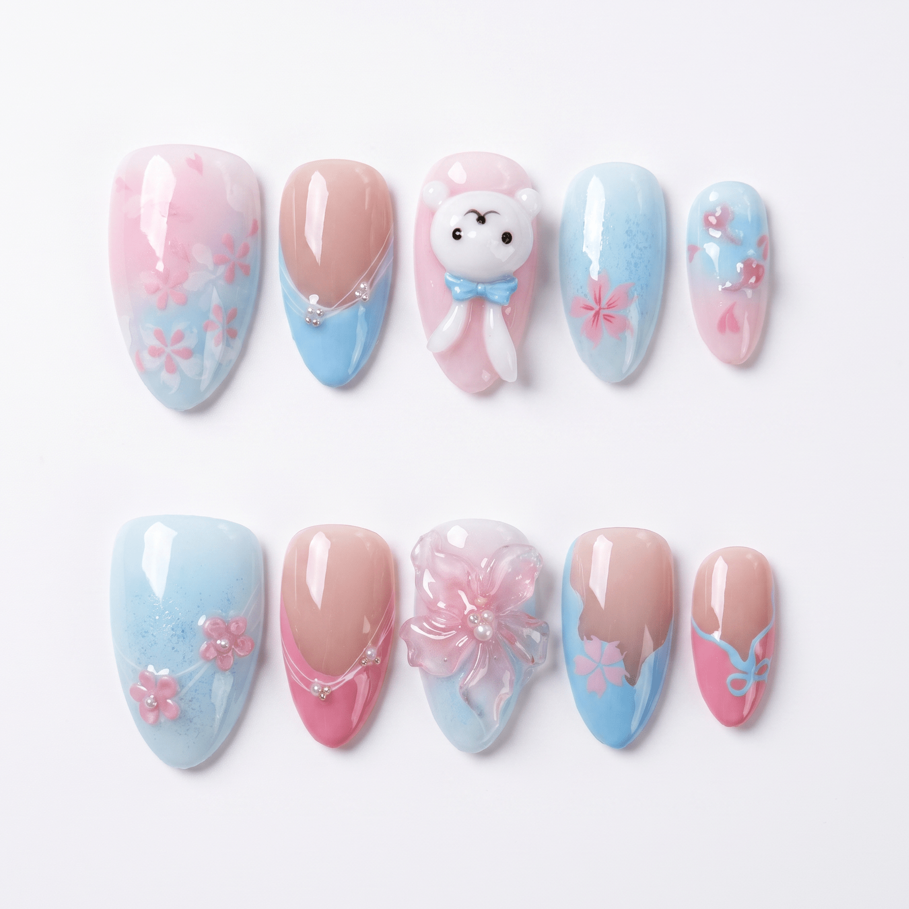 Fresh spring press on nails with pink and blue gradient, floral details, and a cute bunny design. Perfect for soft and romantic looks.