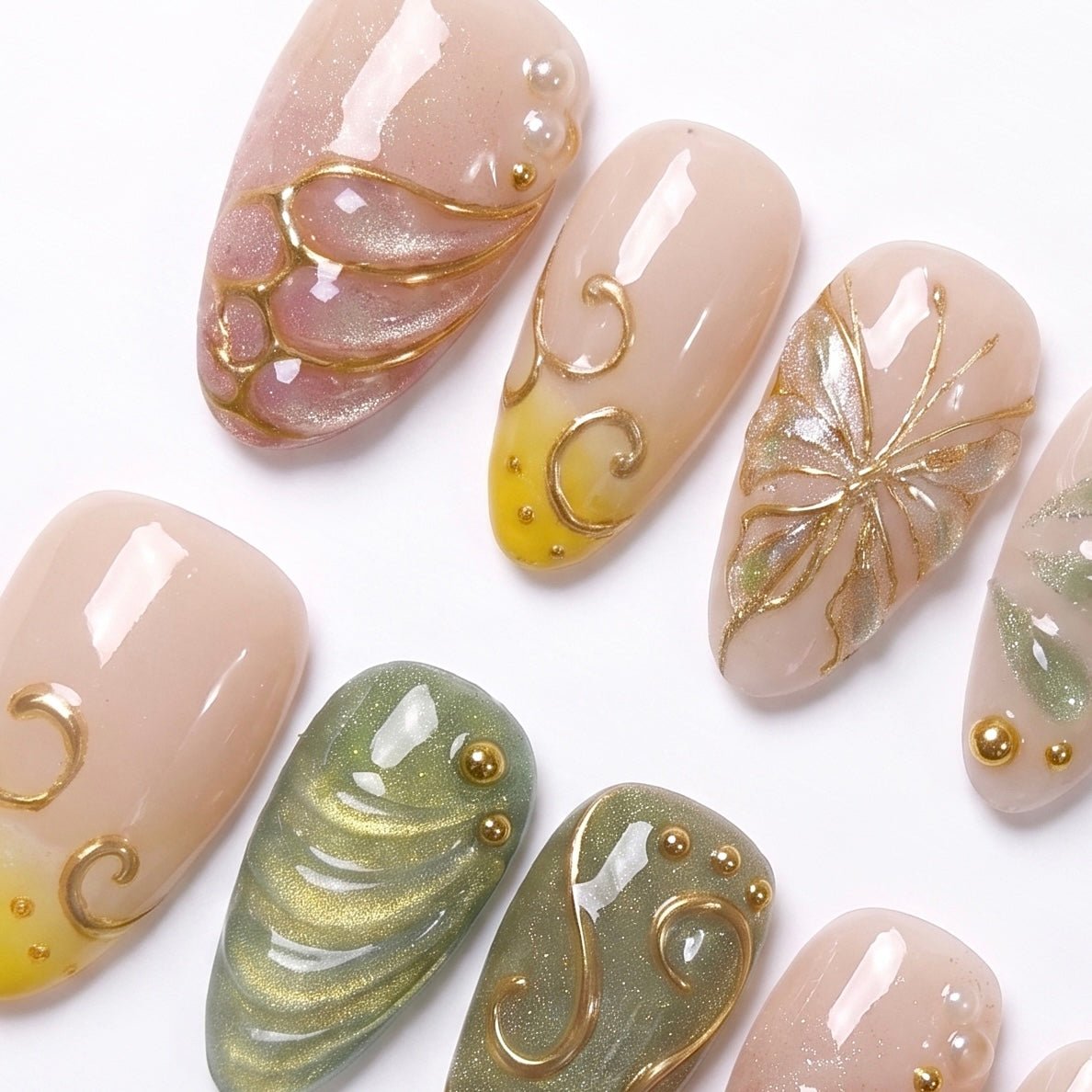 Detailed view of Butterfly Grove nail art with sculpted butterfly wings, shimmering green accents, gold vine swirls, and tiny gold beads