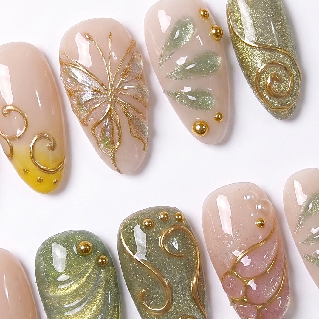 Detailed view of Butterfly Grove nail art with sculpted butterfly wings, shimmering green accents, gold vine swirls, and tiny gold beads
