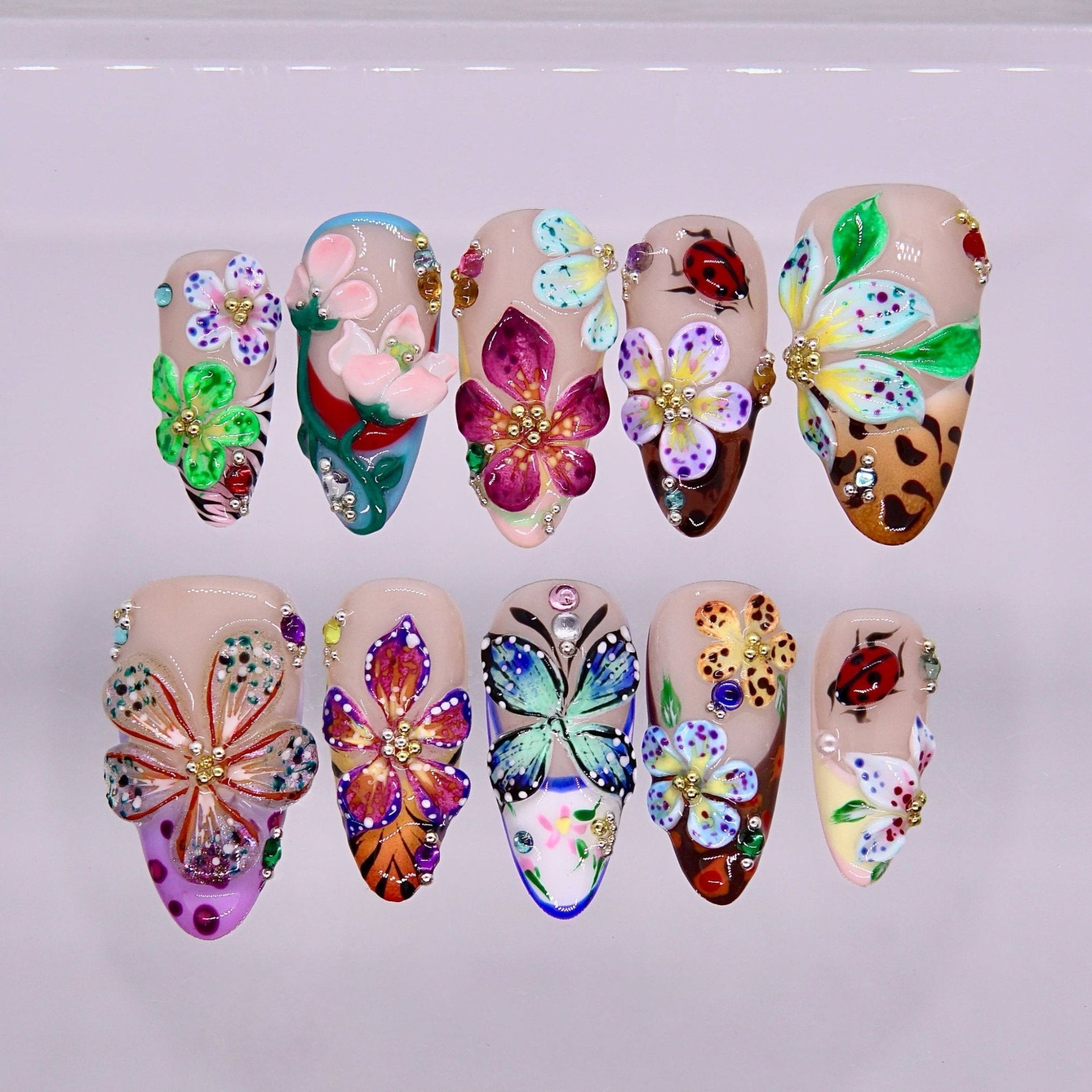 3D flower and butterfly nail art with rhinestone accents