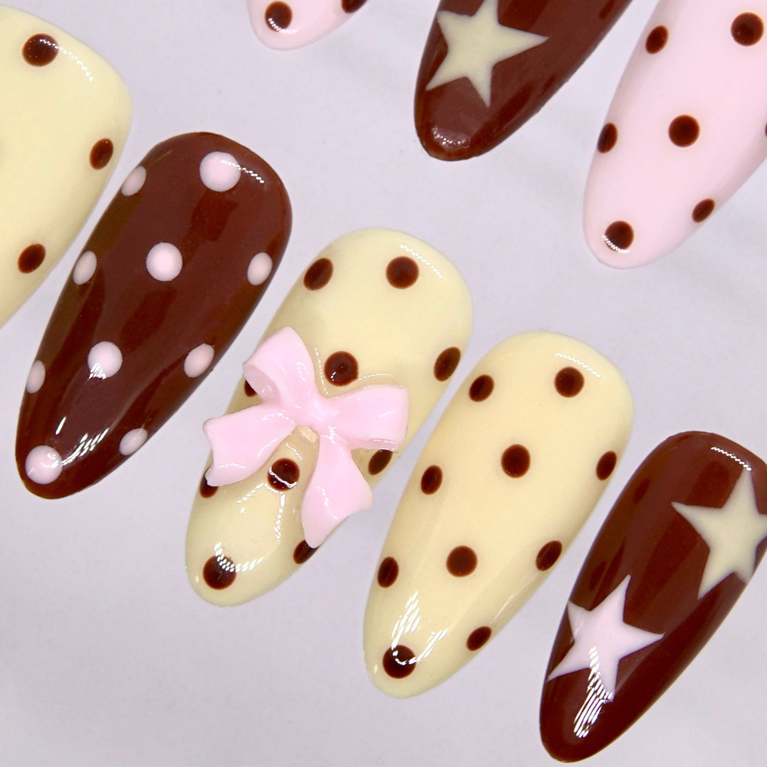 Side view of Choco Daisy press-on nails with star accents and soft retro color palette.