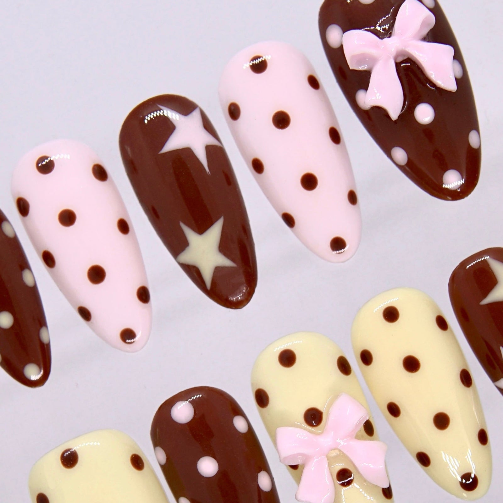 Side view of Choco Daisy press-on nails with star accents and soft retro color palette.