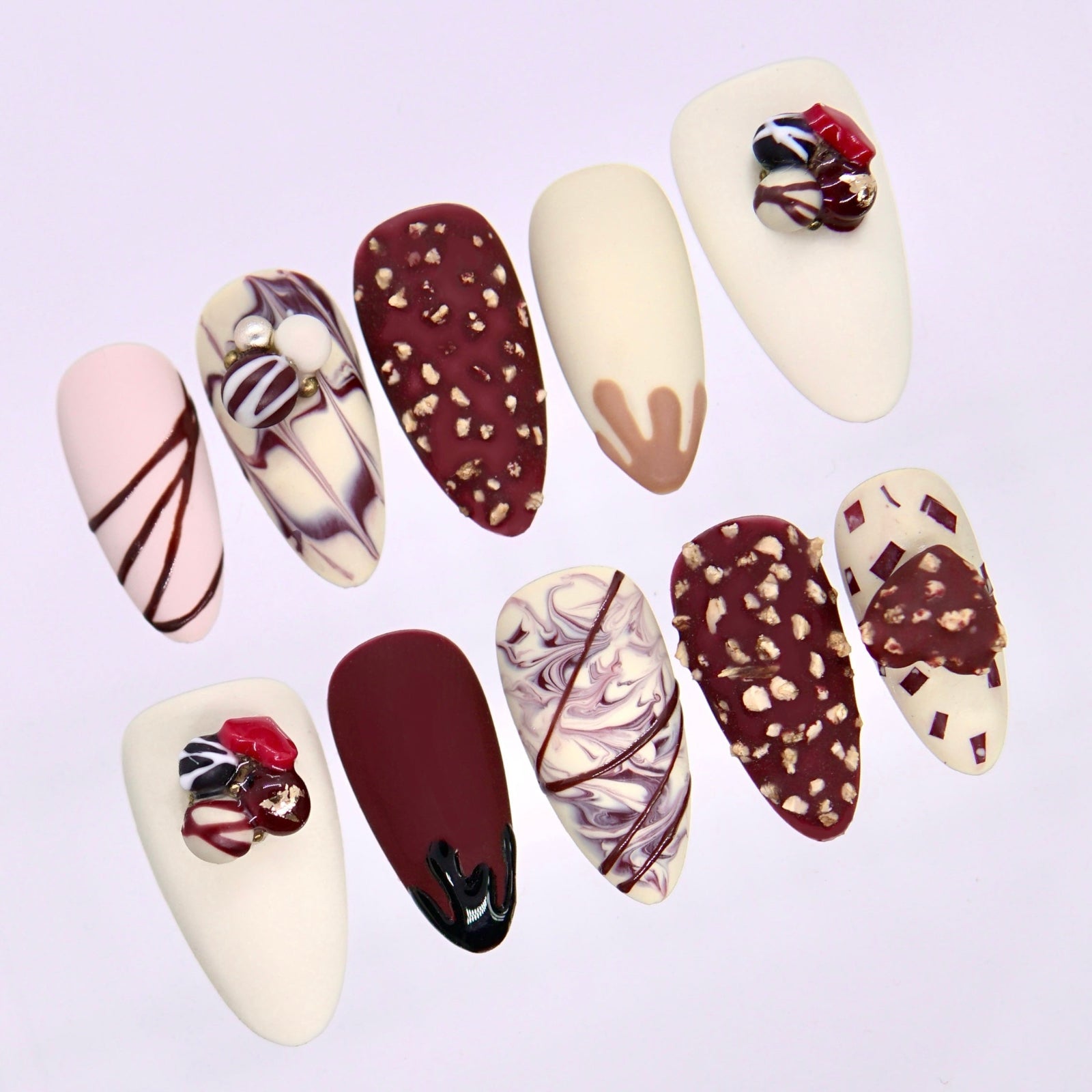 Close up of cream press on nails with chocolate brown marbling and fine line accents
