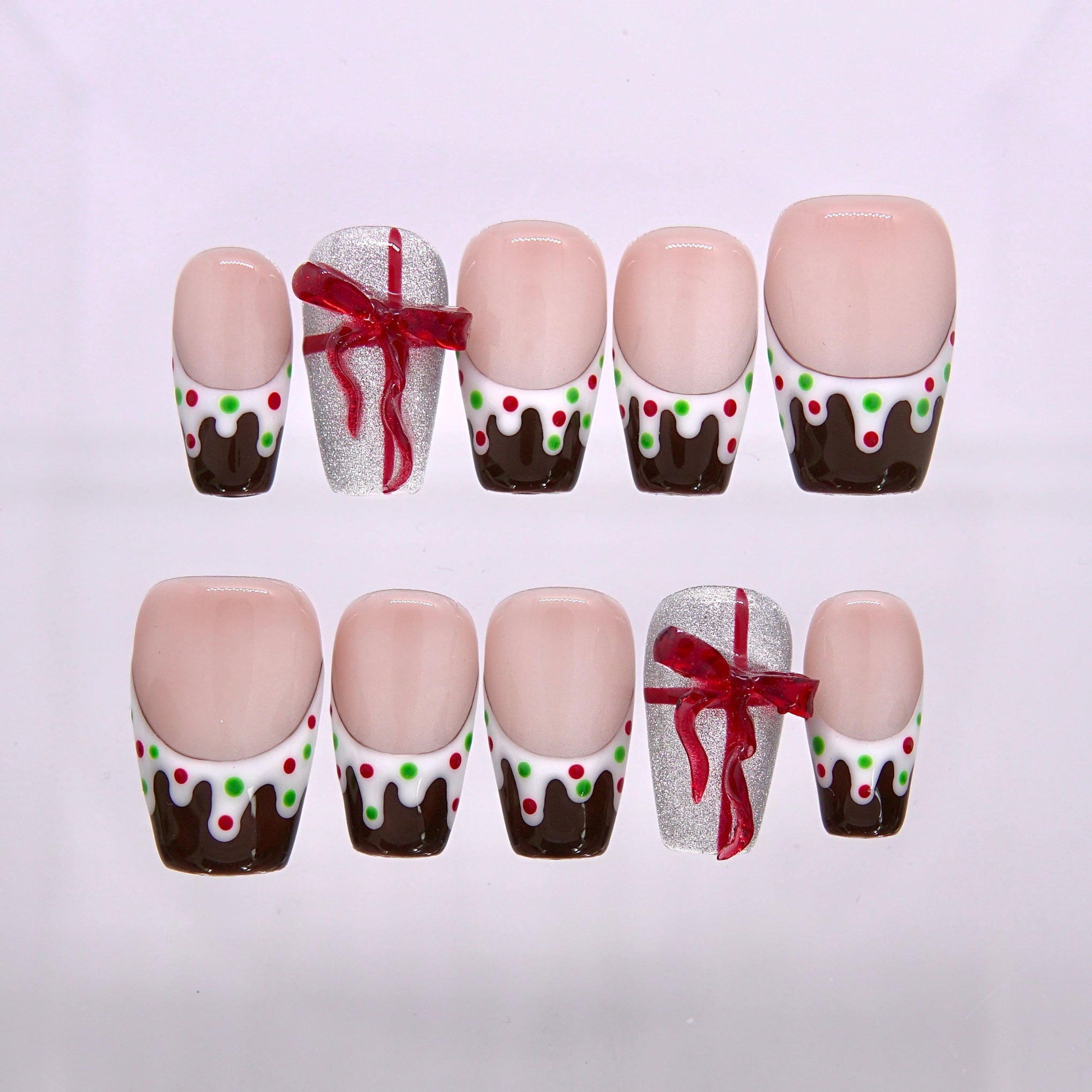 Cocoa Drip Wonderland Christmas press on nails with chocolate drips white icing and festive candy dot details.