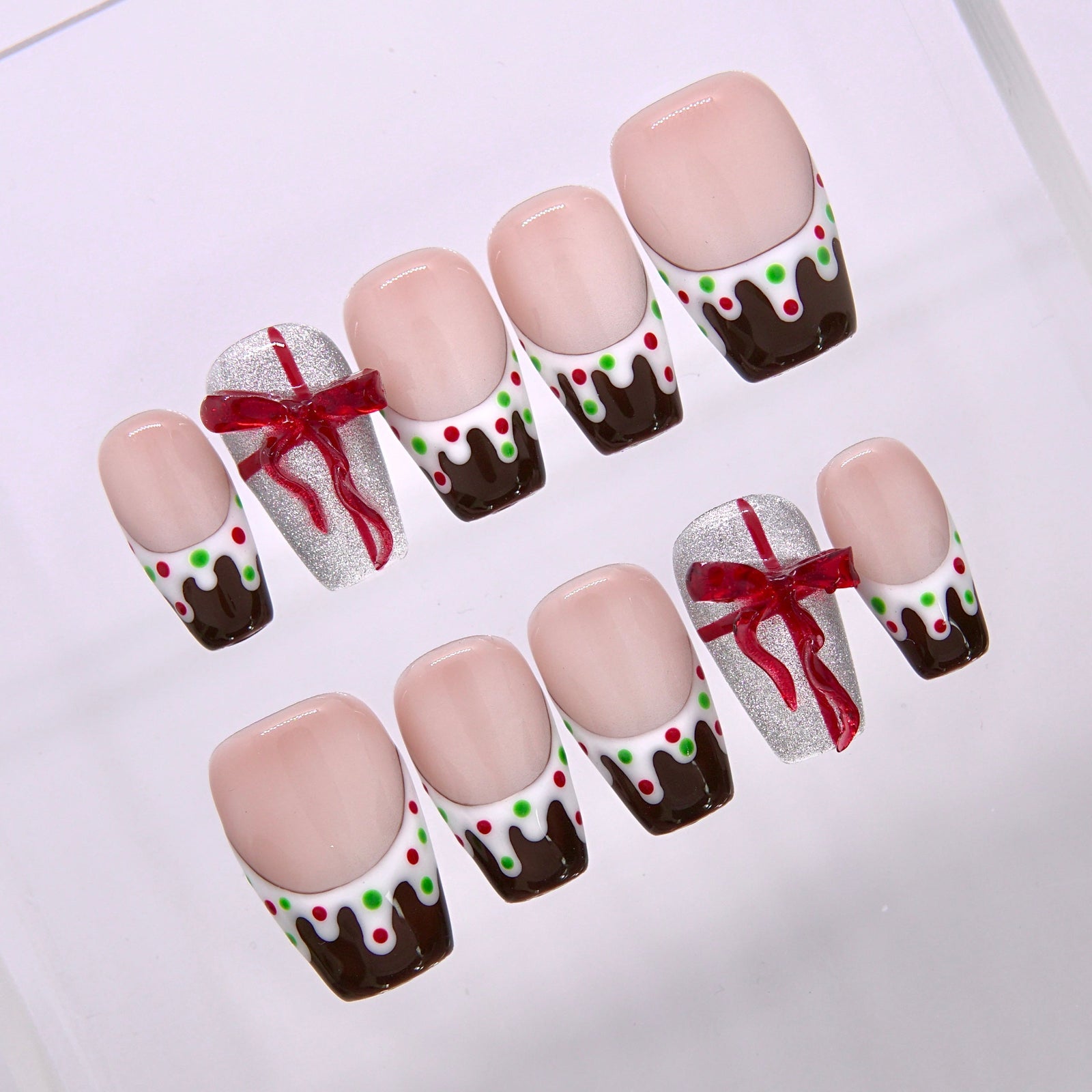 Close up of chocolate drip nail art with green and red candy accents and glossy holiday shine.